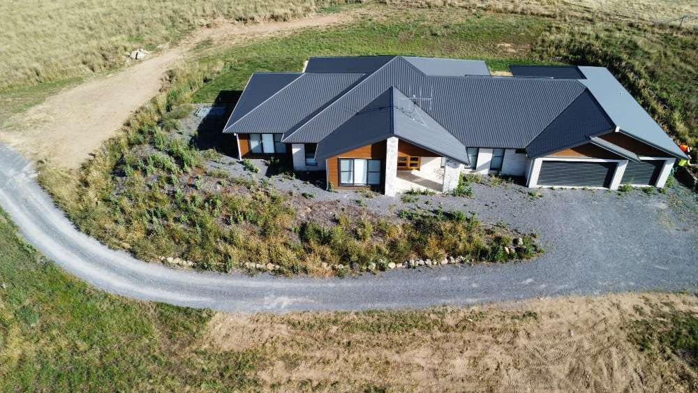 Before An Aerial View Of A House With A Black Roof And A Driveway — Canberra Home and Garden Maintenance in Tuggeranong ACT