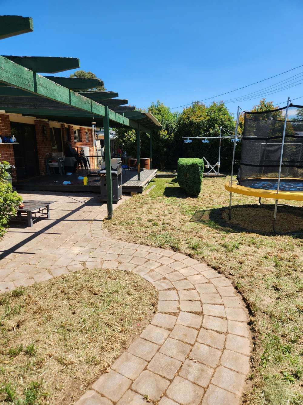 After A Brick Walkway Leading To A House With A Trampoline In The Backyard — Canberra Home and Garden Maintenance in Tuggeranong ACT