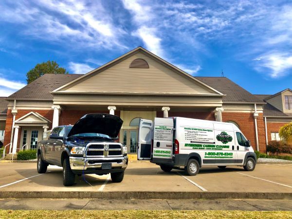 Two trucks and a van are parked in front of a building | HHO Carbon Clean Systems - North Atlanta