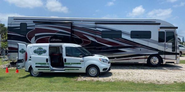 A white van is parked next to a large rv | HHO Carbon Clean Systems - North Atlanta