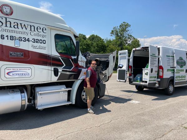 A man is standing next to a truck that says shawnee community college | HHO Carbon Clean Systems - North Atlanta