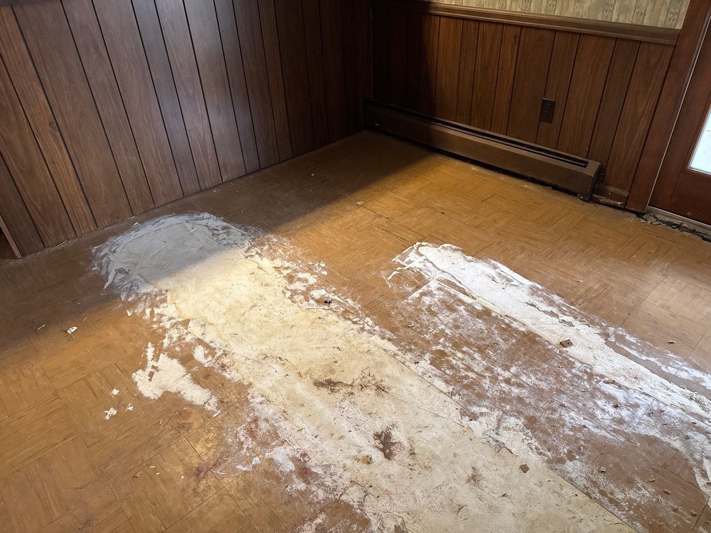 A room with wood paneling and a lot of white powder on the floor.