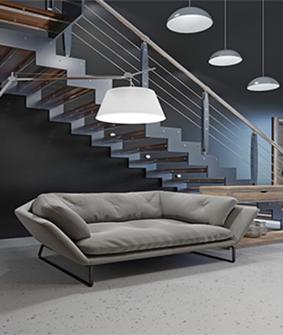 Modern living room with grey sofa, staircase, and pendant lights.