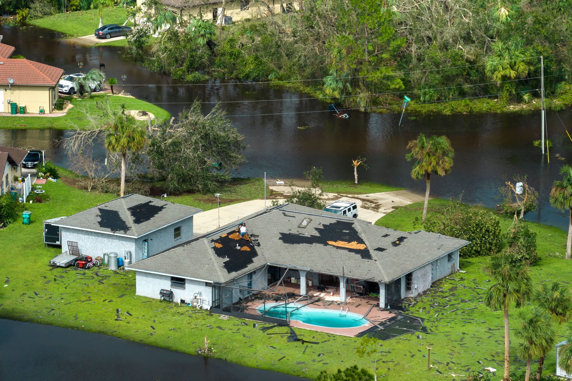 Hurricane Ian destroyed house with damaged roof and lanai enclosure