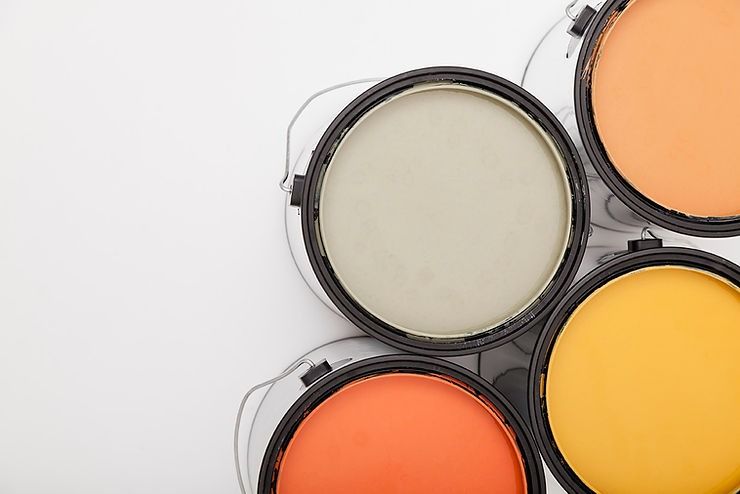 Four buckets of paint are stacked on top of each other on a white background.