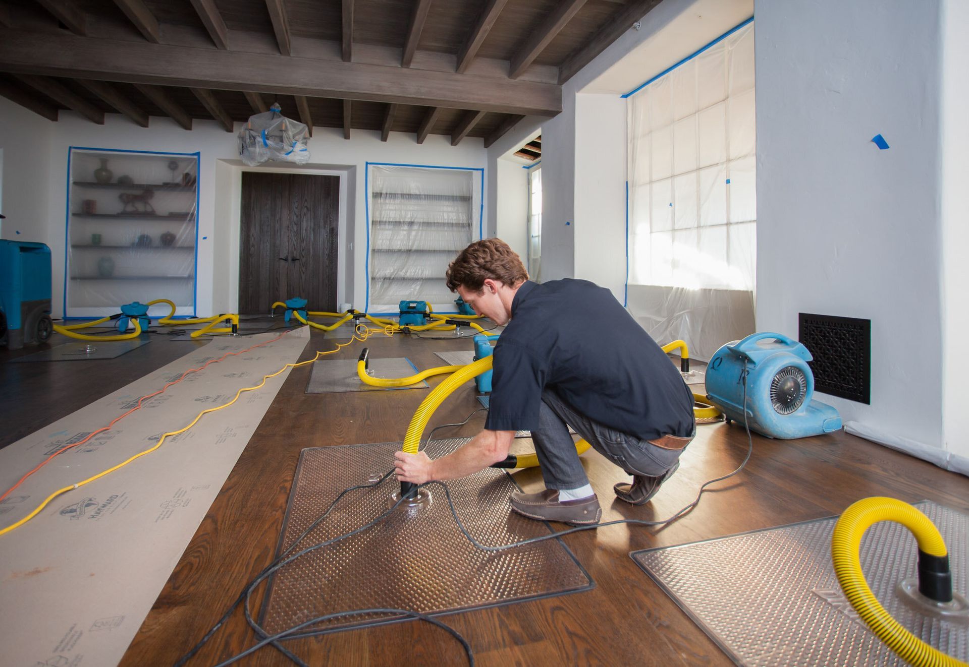 A man is working on a wooden floor Denver Colorado how to deal with water damage