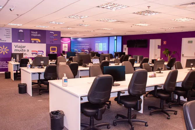 Sala de treinamento em informática com fileiras de mesas e monitores