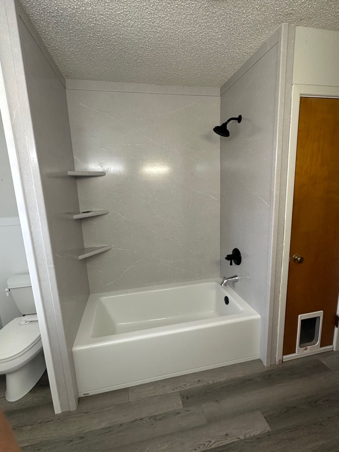 A bathroom with a bathtub , toilet and shower.
