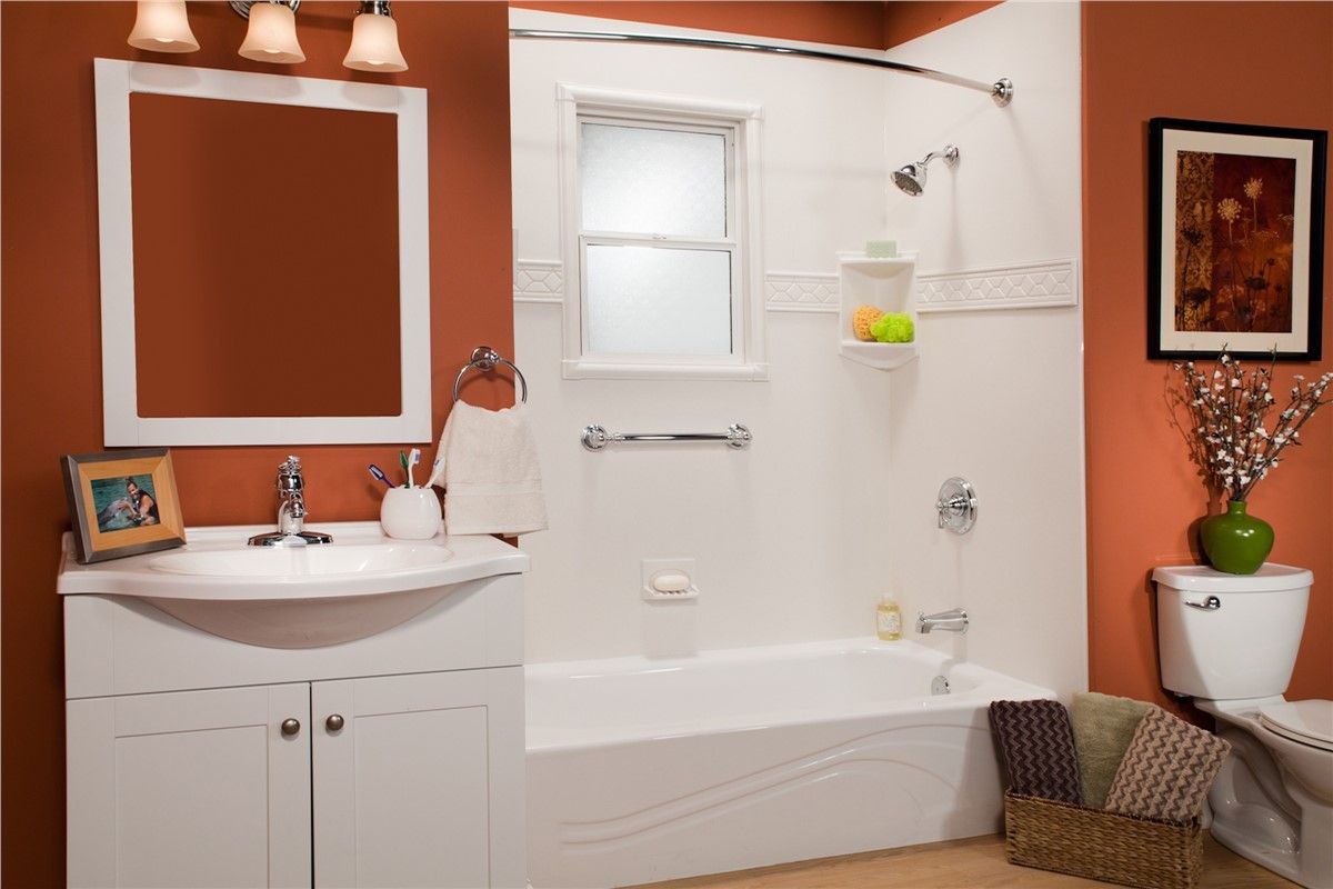 A bathroom with a sink , tub , mirror and toilet.