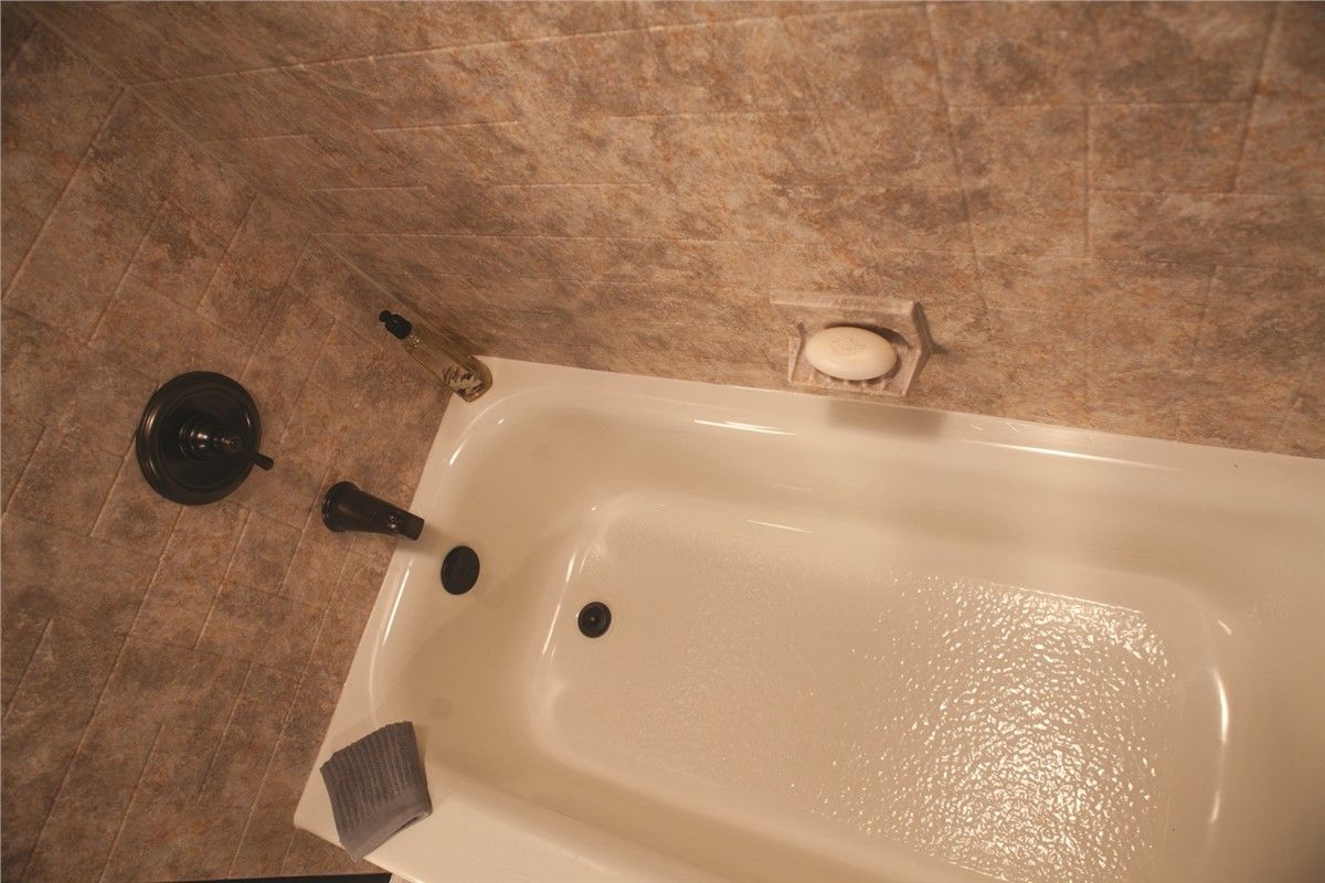 A bathtub in a bathroom with a soap dish on the wall.