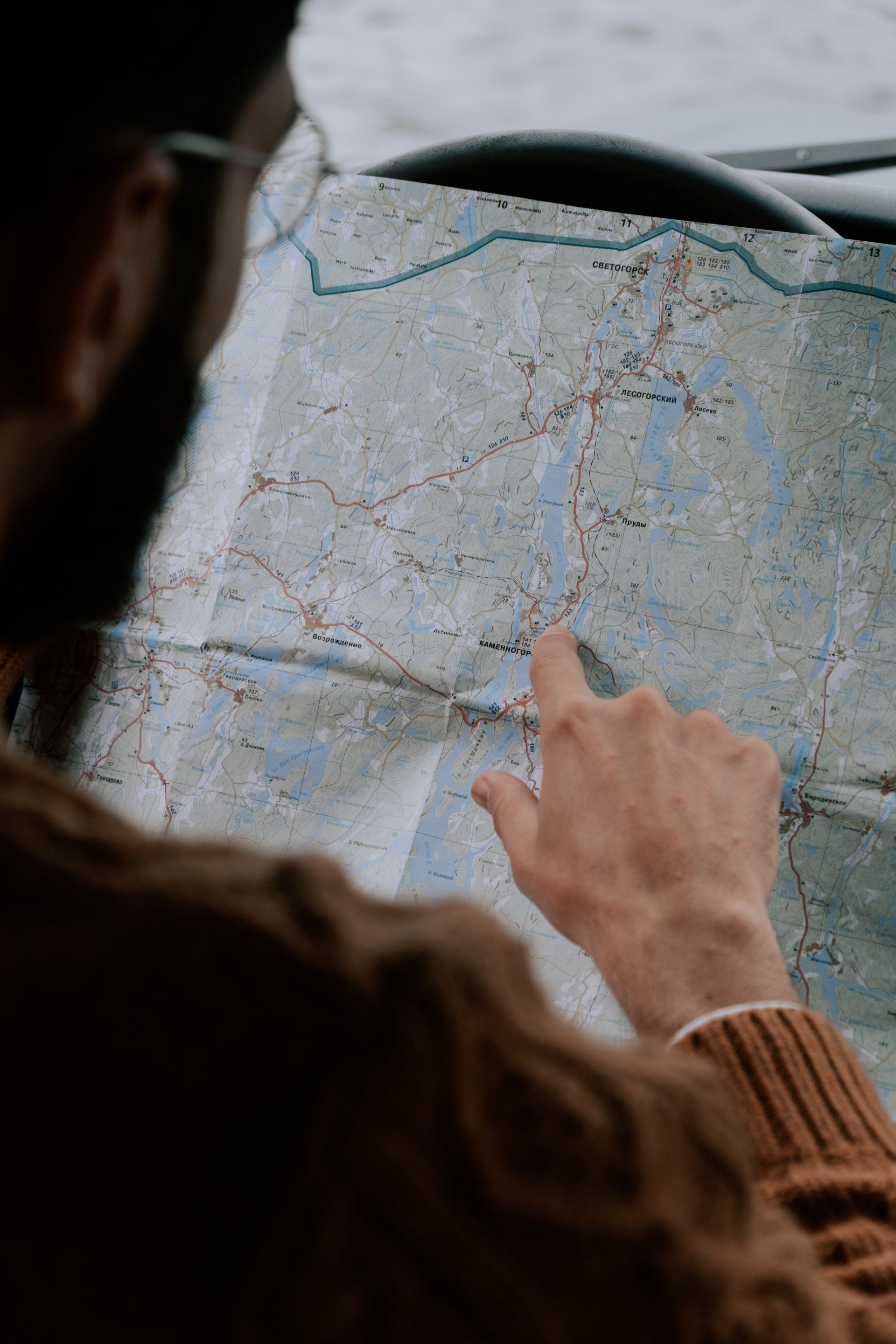 A man is pointing at a map on a table.