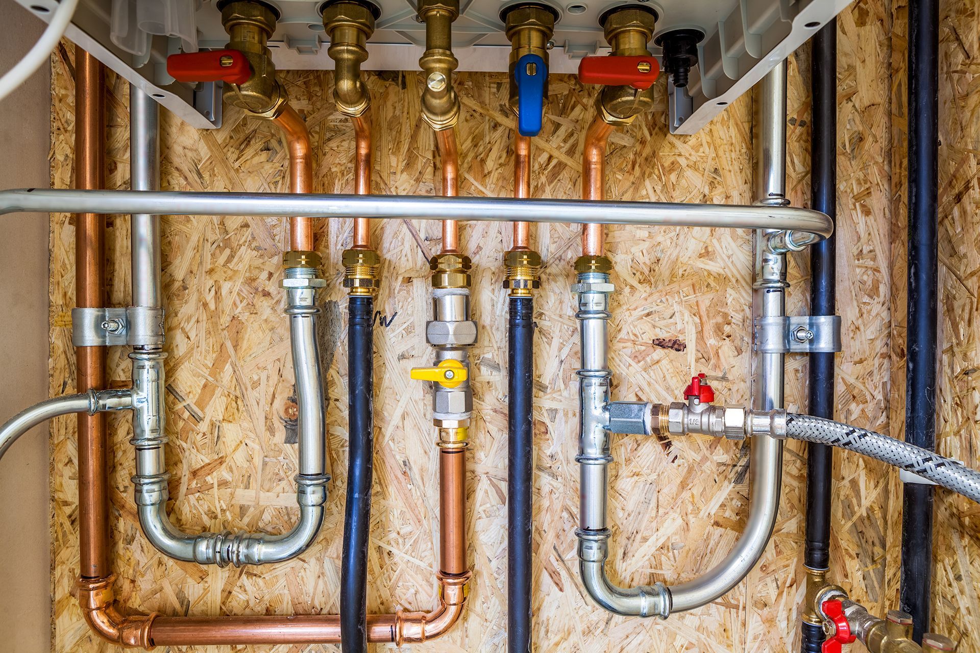 A close up of a boiler with copper pipes and valves.