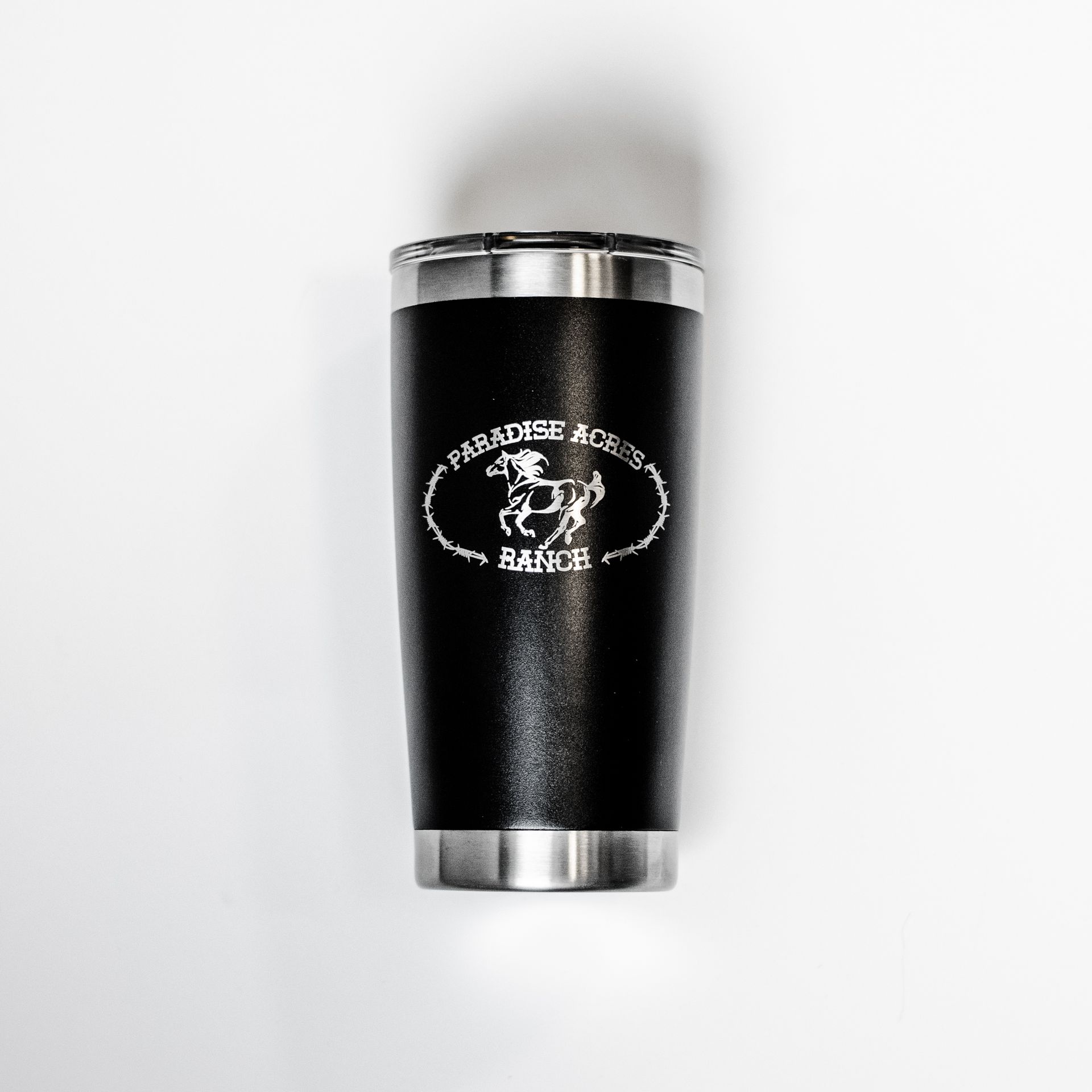 A black tumbler with the word paradise on it