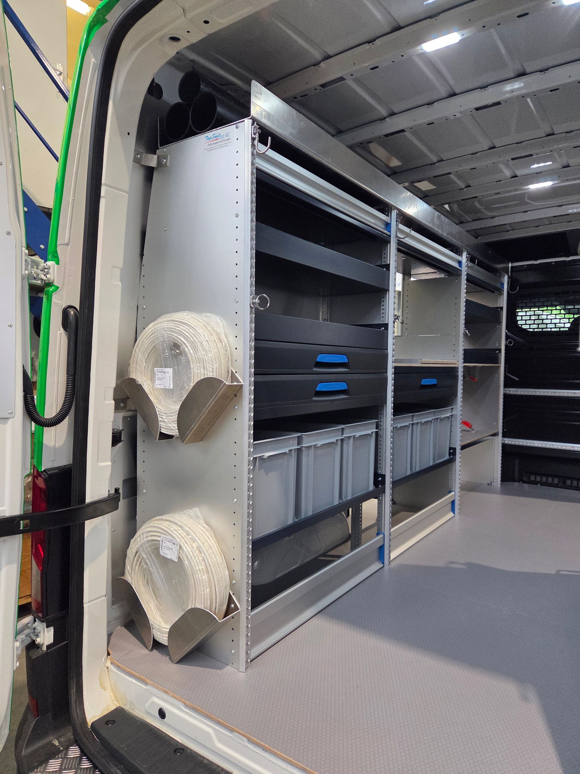 Innenansicht eines Lieferwagens: Aufbewahrungssystem mit Schubladen, Behältern und Papierhandtuchhaltern.