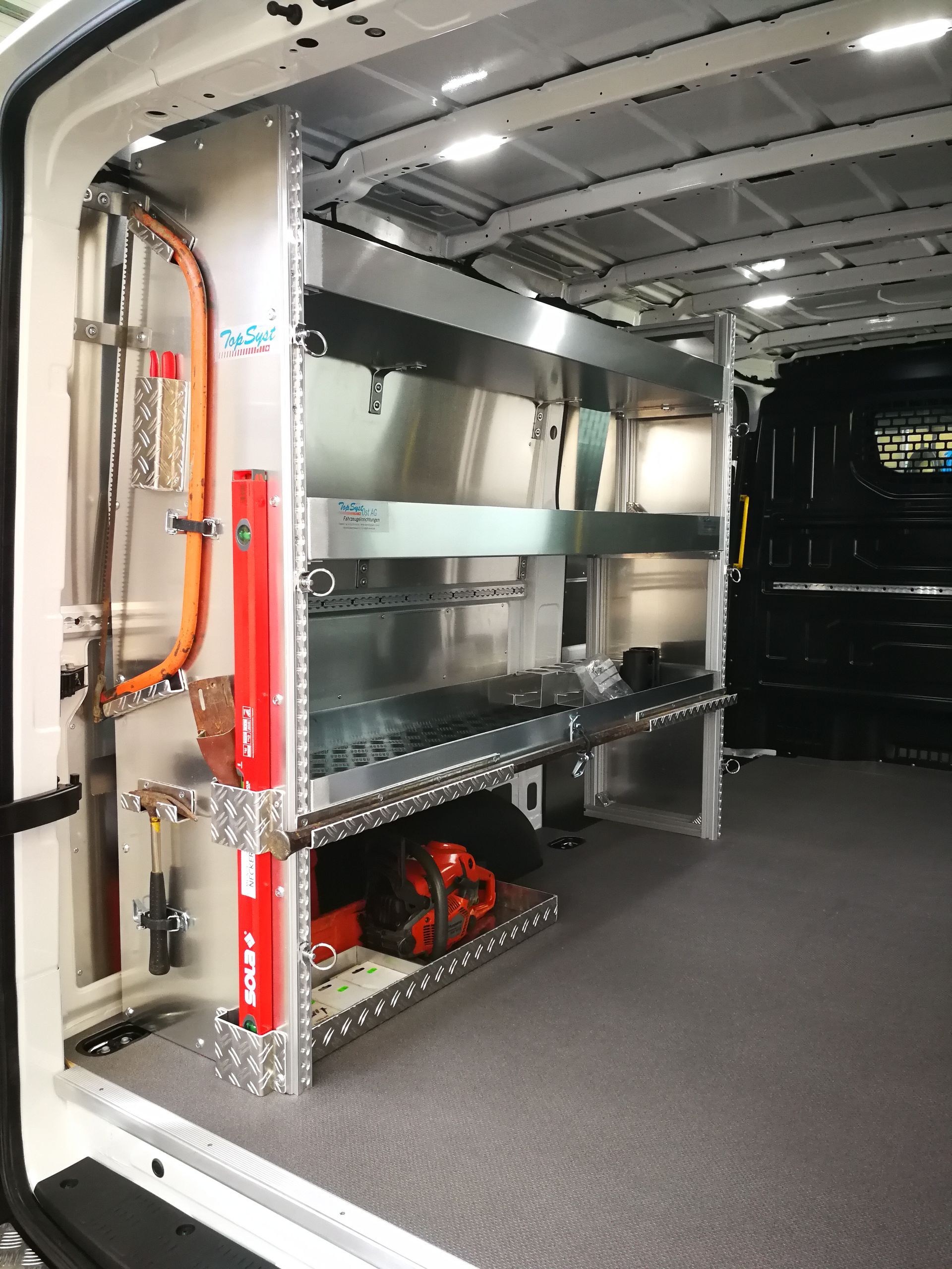 In einem Arbeitswagen: Metallregal mit Werkzeugen und Zubehör.