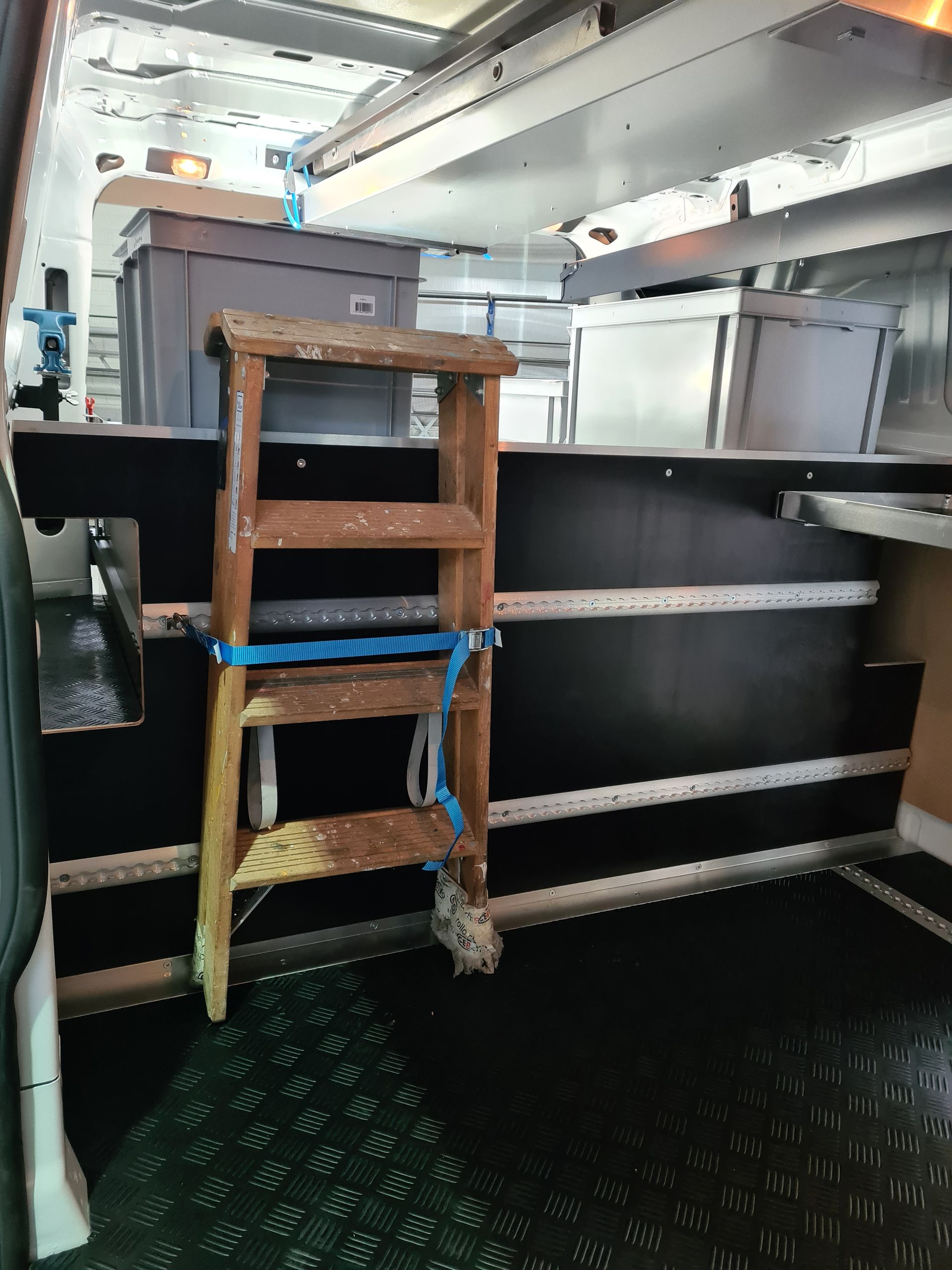 Im Fahrzeuginneren ist ein Tritthocker aus Holz mit einem blauen Seil befestigt.