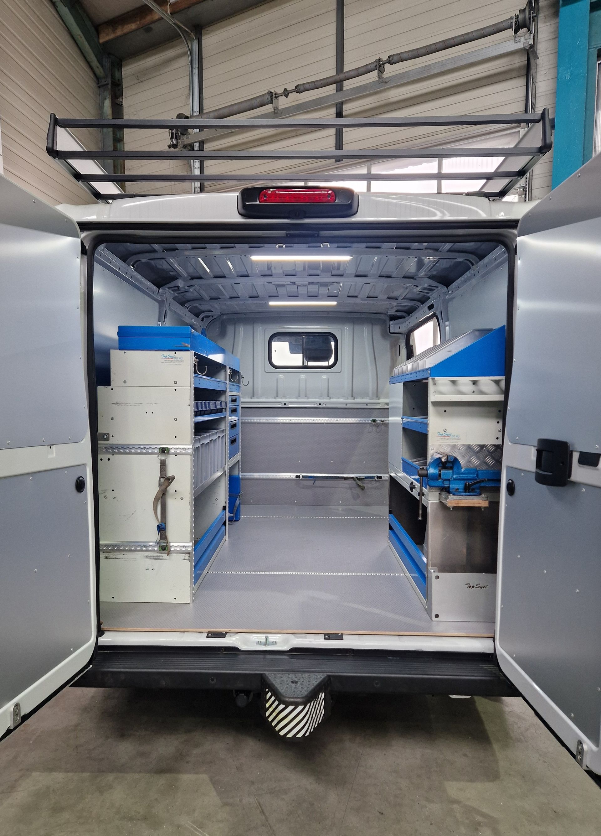 Offener Innenraum eines Lieferwagens, Regale, Werkzeuge, blau und grau, Gepäckträger, Werkstatt.