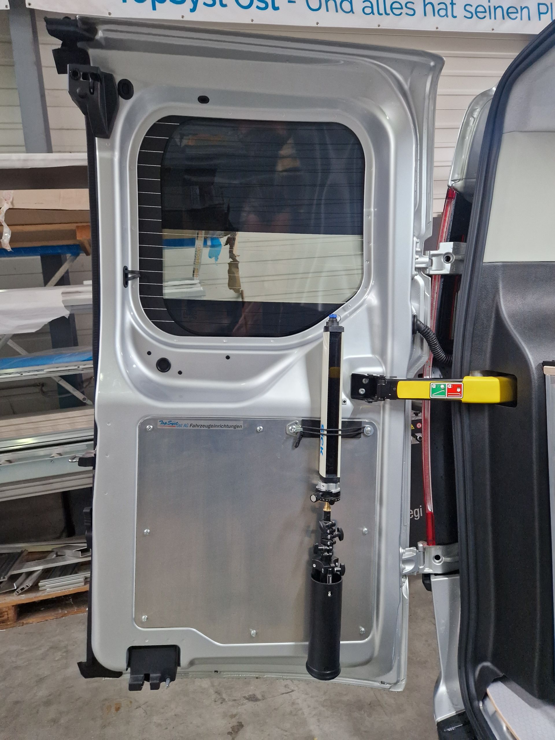 Offene Lieferwagentür mit silbernem Rahmen und montierter Wasserwaage.