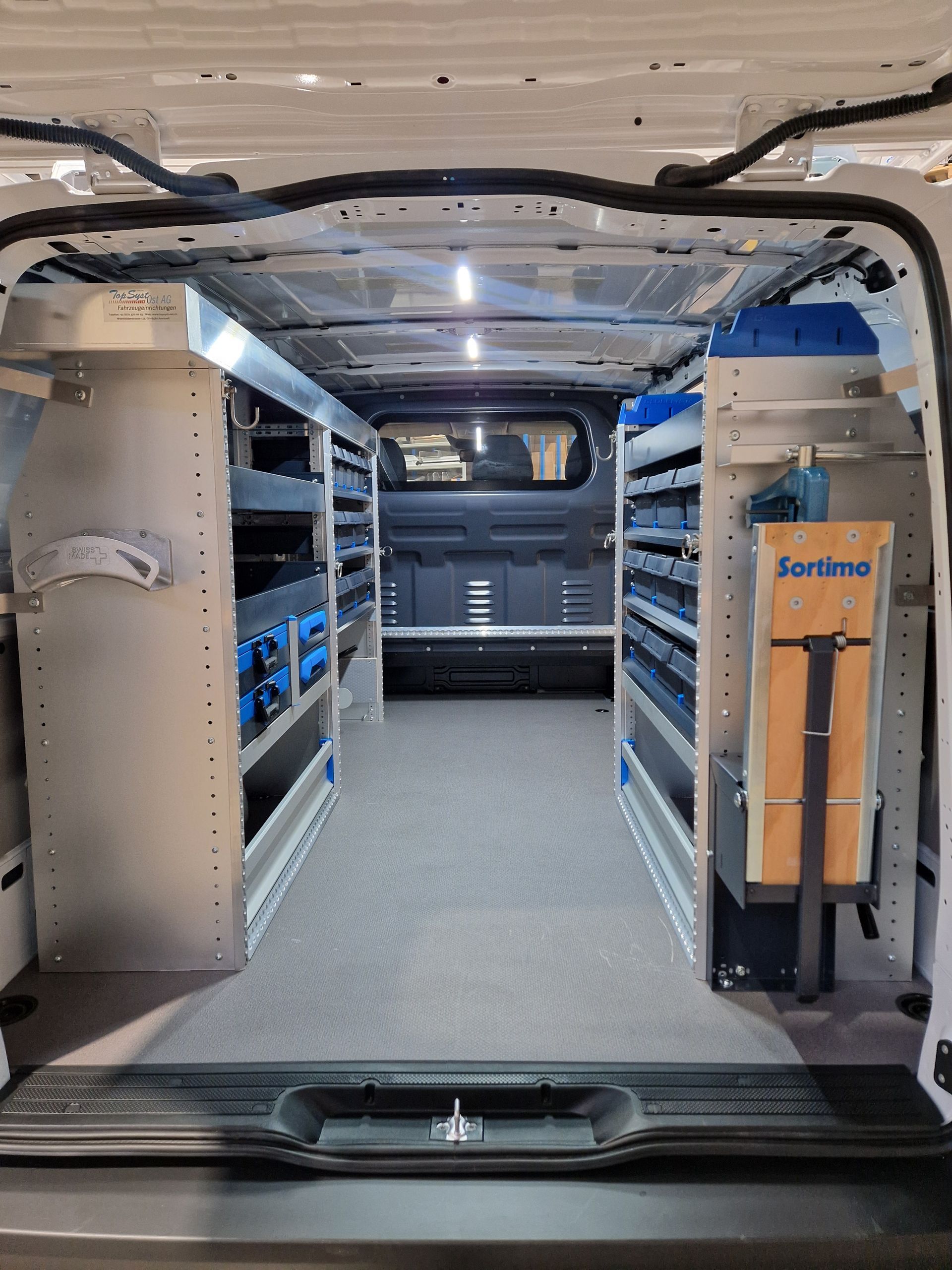 Innenansicht eines Servicewagens mit Regalen und für die Arbeit organisierten Werkzeugen.