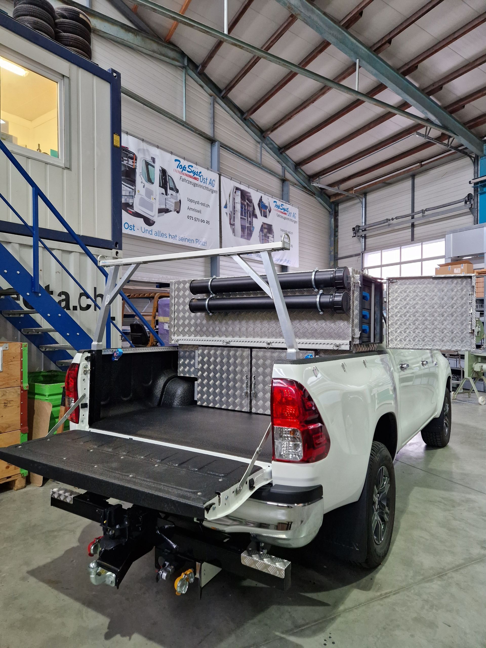 Weißer Pickup-Truck mit kundenspezifischer Werkzeugaufbewahrung und Regalen in einem Lagerhaus.