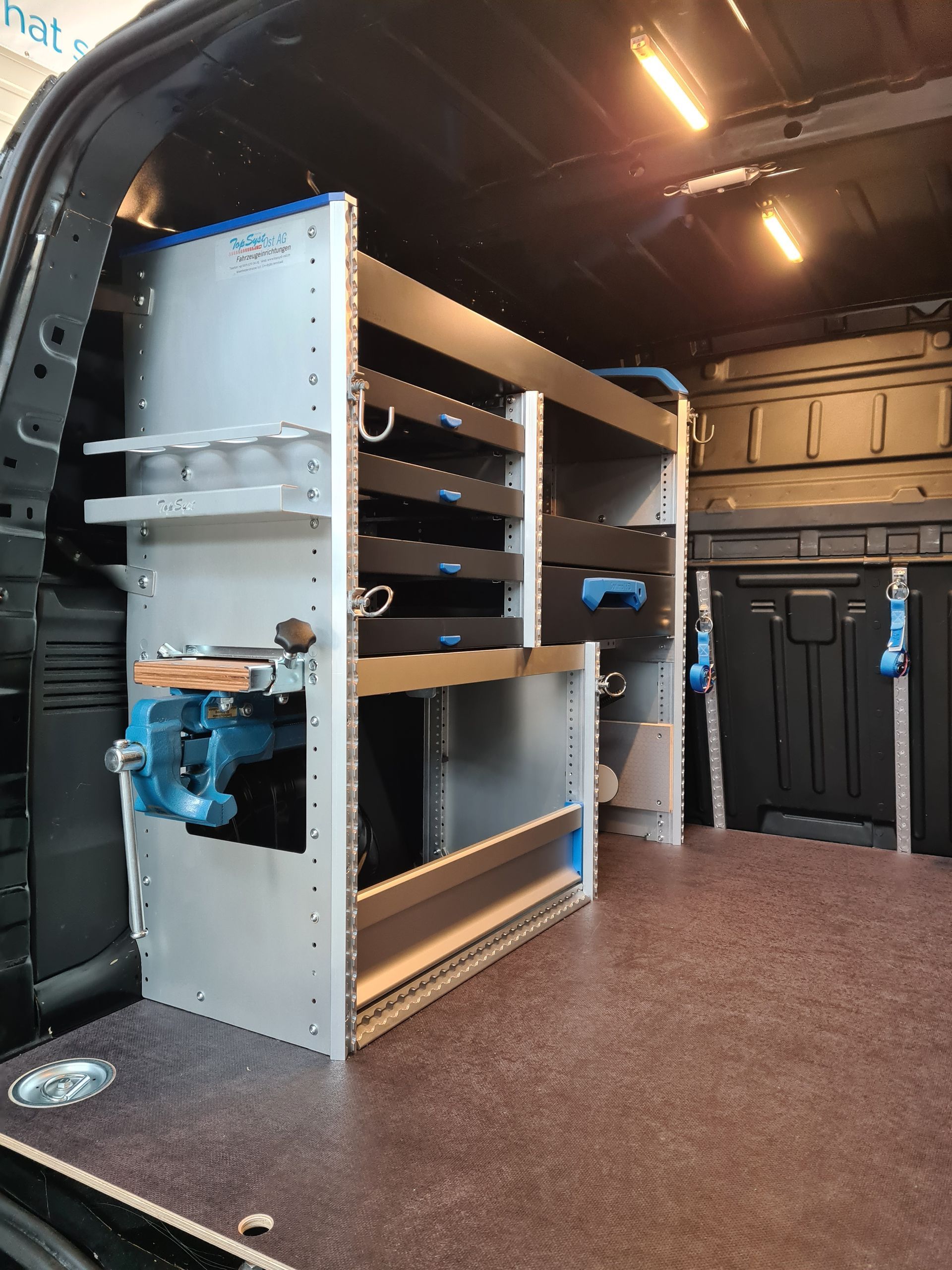 Innenraum eines Lieferwagens mit Regalen für Werkzeuge und Ausrüstung.