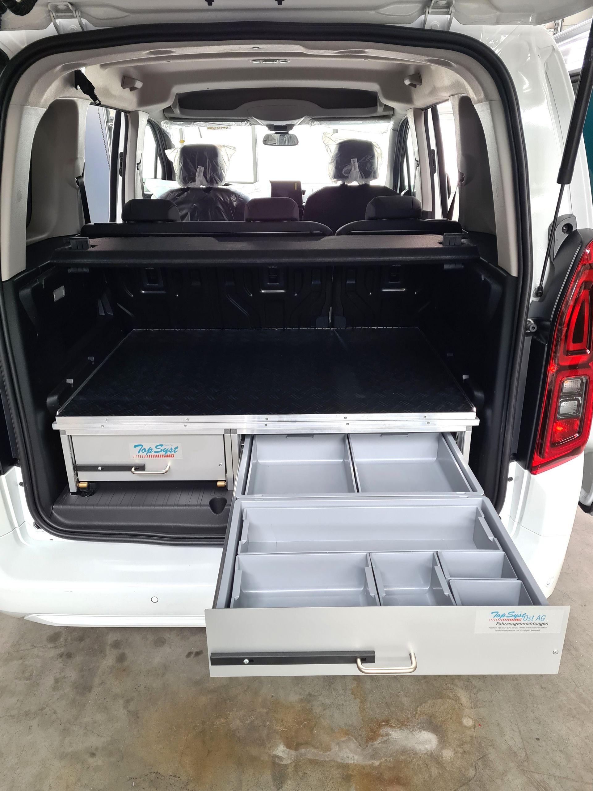 Weißer Van-Innenraum mit offenen Schubladen.