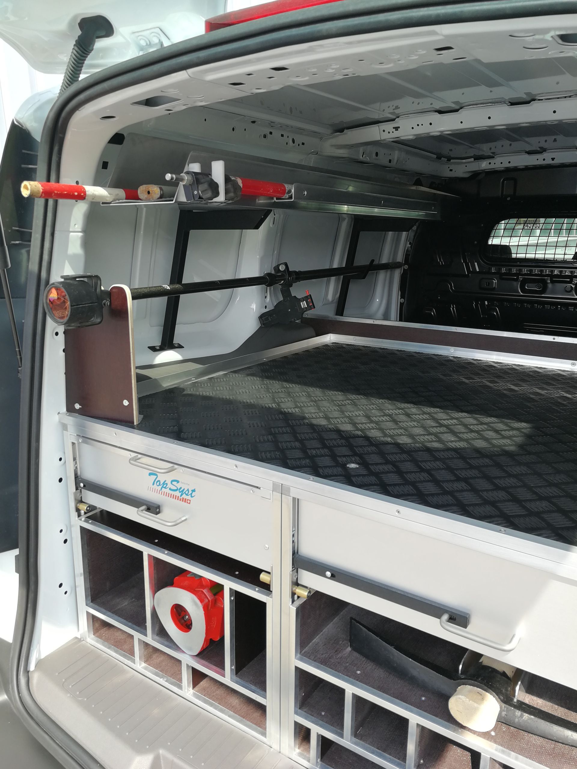 Van-Innenraum mit maßgefertigten Ablagefächern für Werkzeuge und Ausrüstung.