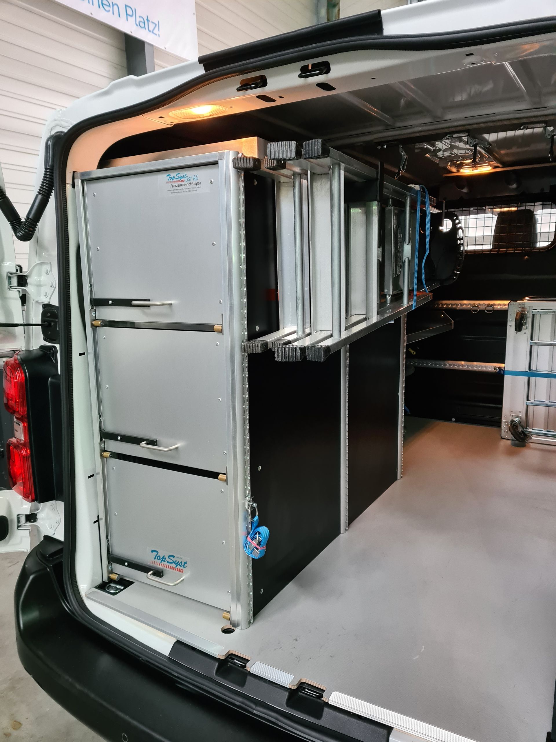 Innenraum eines Lieferwagens mit maßgefertigten Regalen. Metallschränke und Stauraum an der Seite.