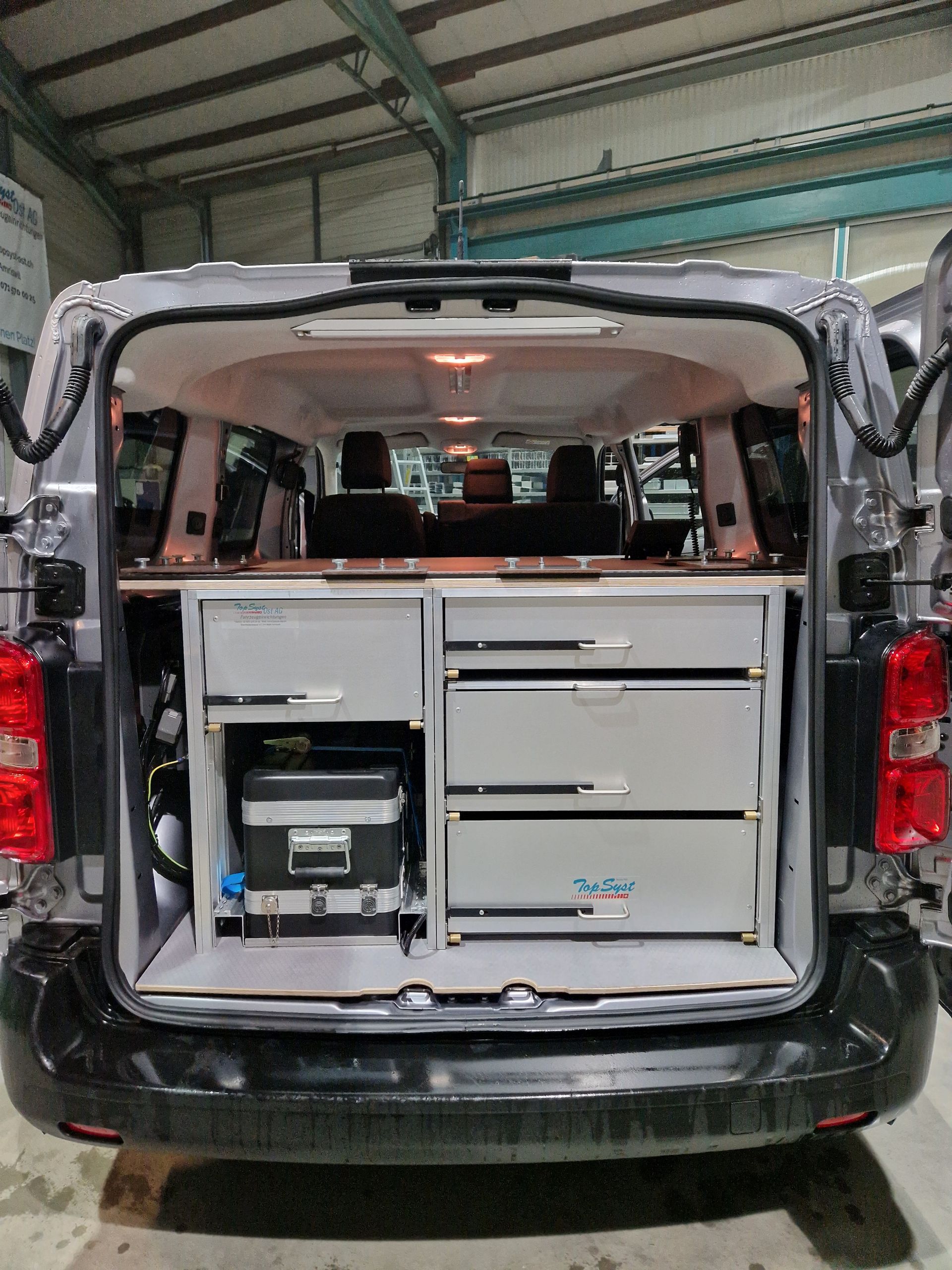 Van-Innenraum mit Schubladen und Ausstattung. Graue und weiße Farben.