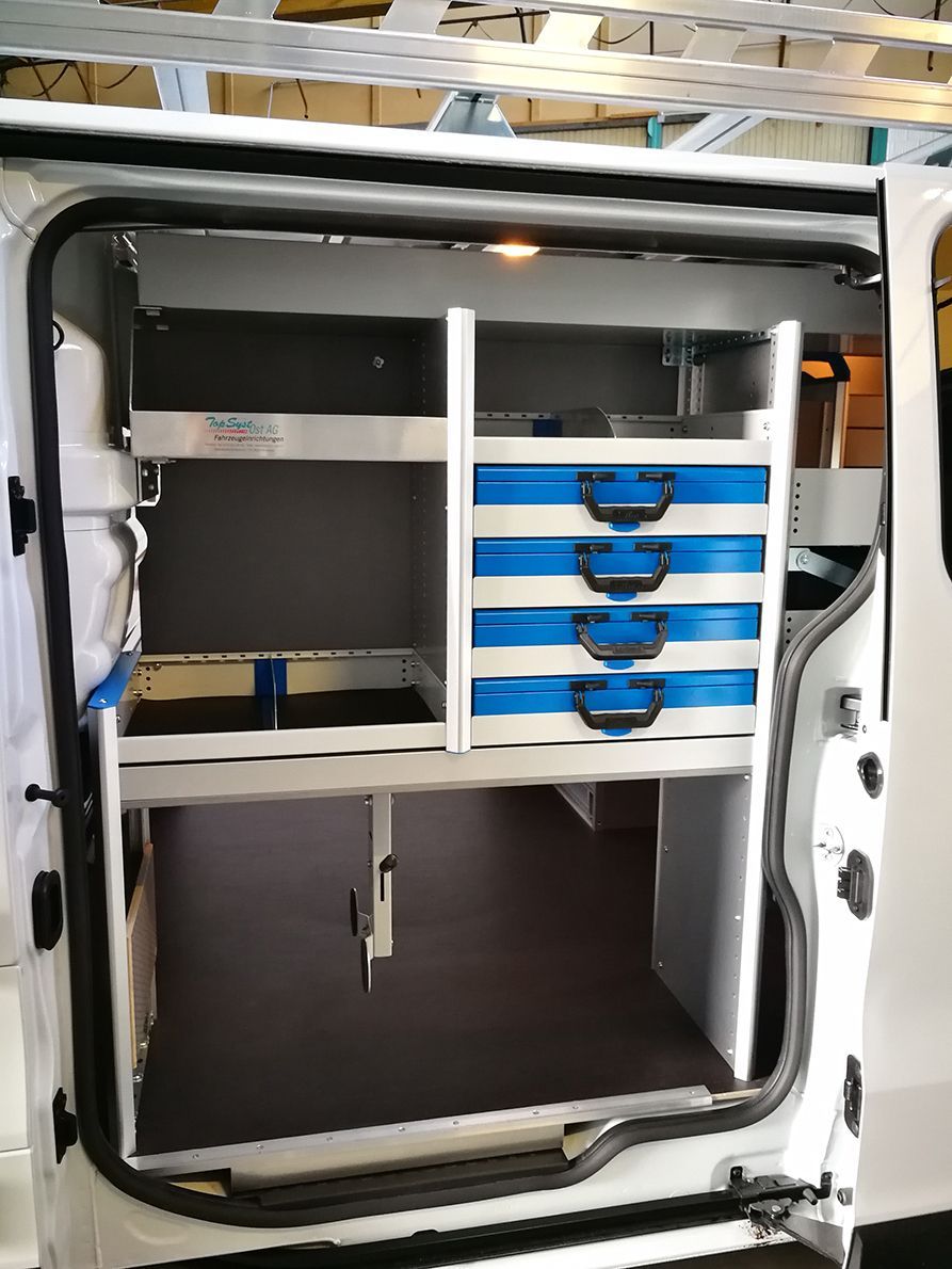 Im Inneren eines weißen Lieferwagens: Regal mit blauen Schubladen.