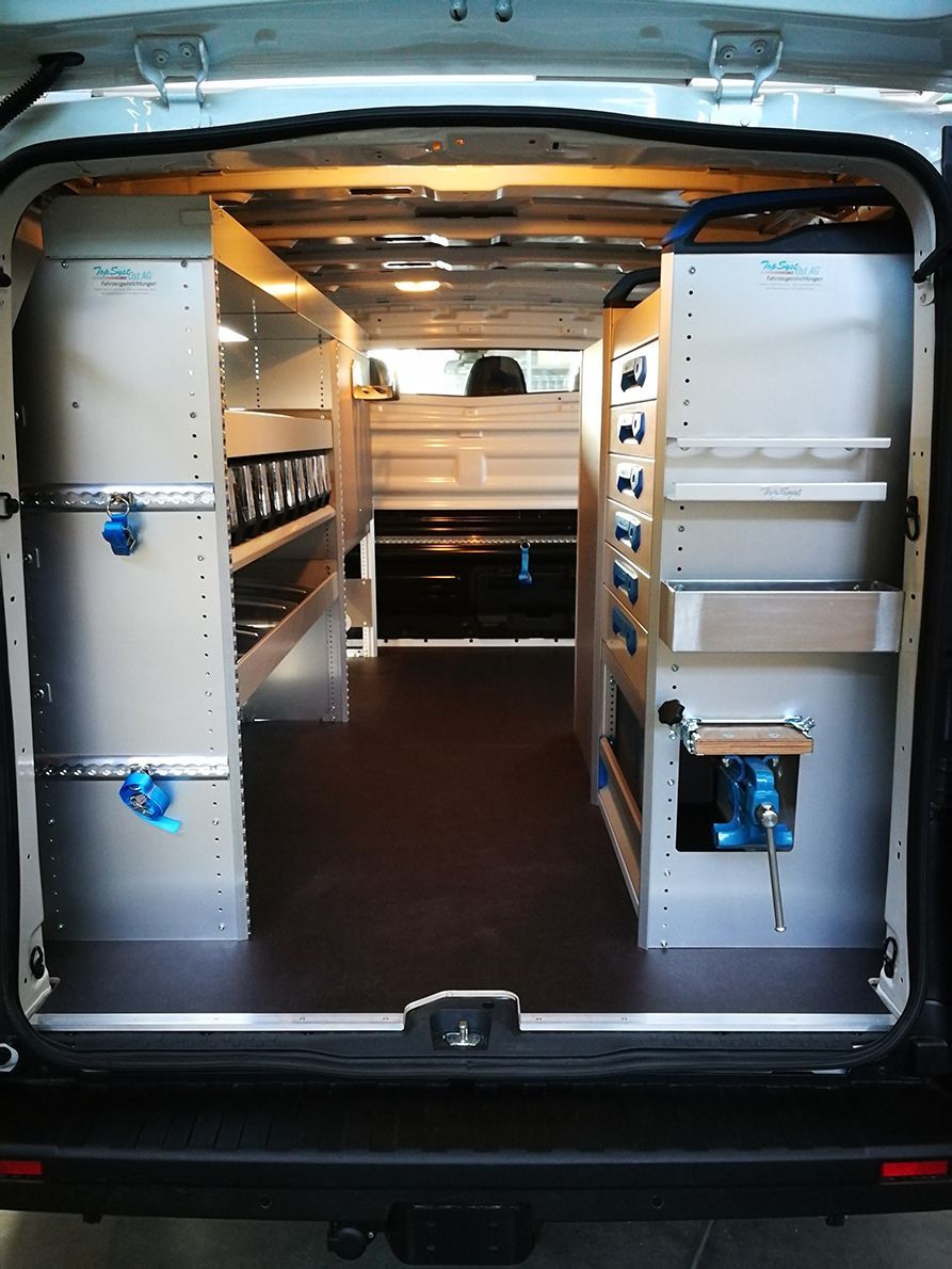 Innenraum eines weißen Lieferwagens mit maßgefertigten Regalen für Werkzeuge und Ausrüstung.
