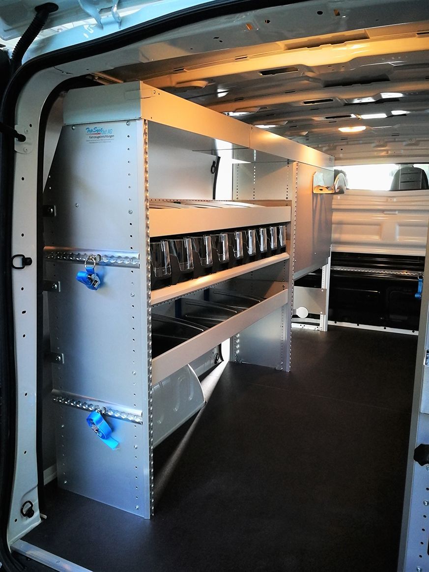 Innenraum eines weißen Lieferwagens mit Regalen zur Aufbewahrung, der Boden ist schwarz.