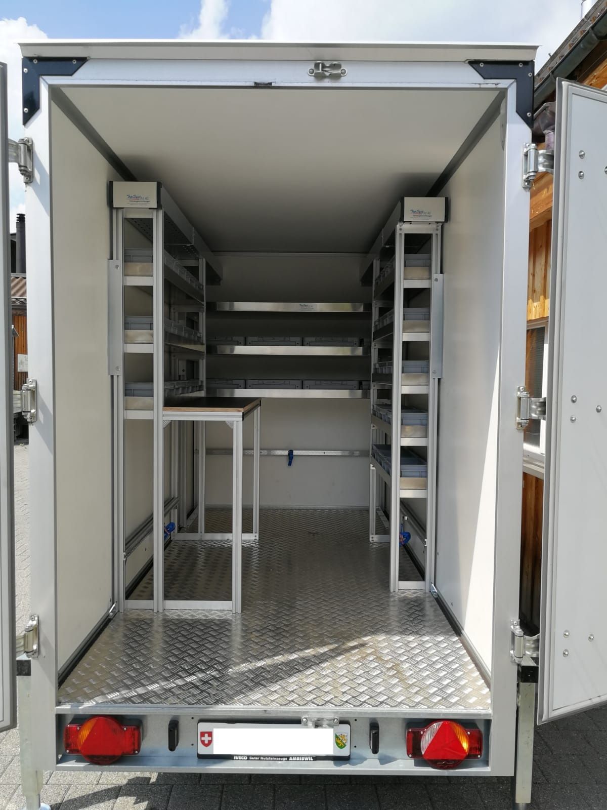 Das Innere eines Anhängers mit Regalen und einem Nummernschild mit der Aufschrift 3