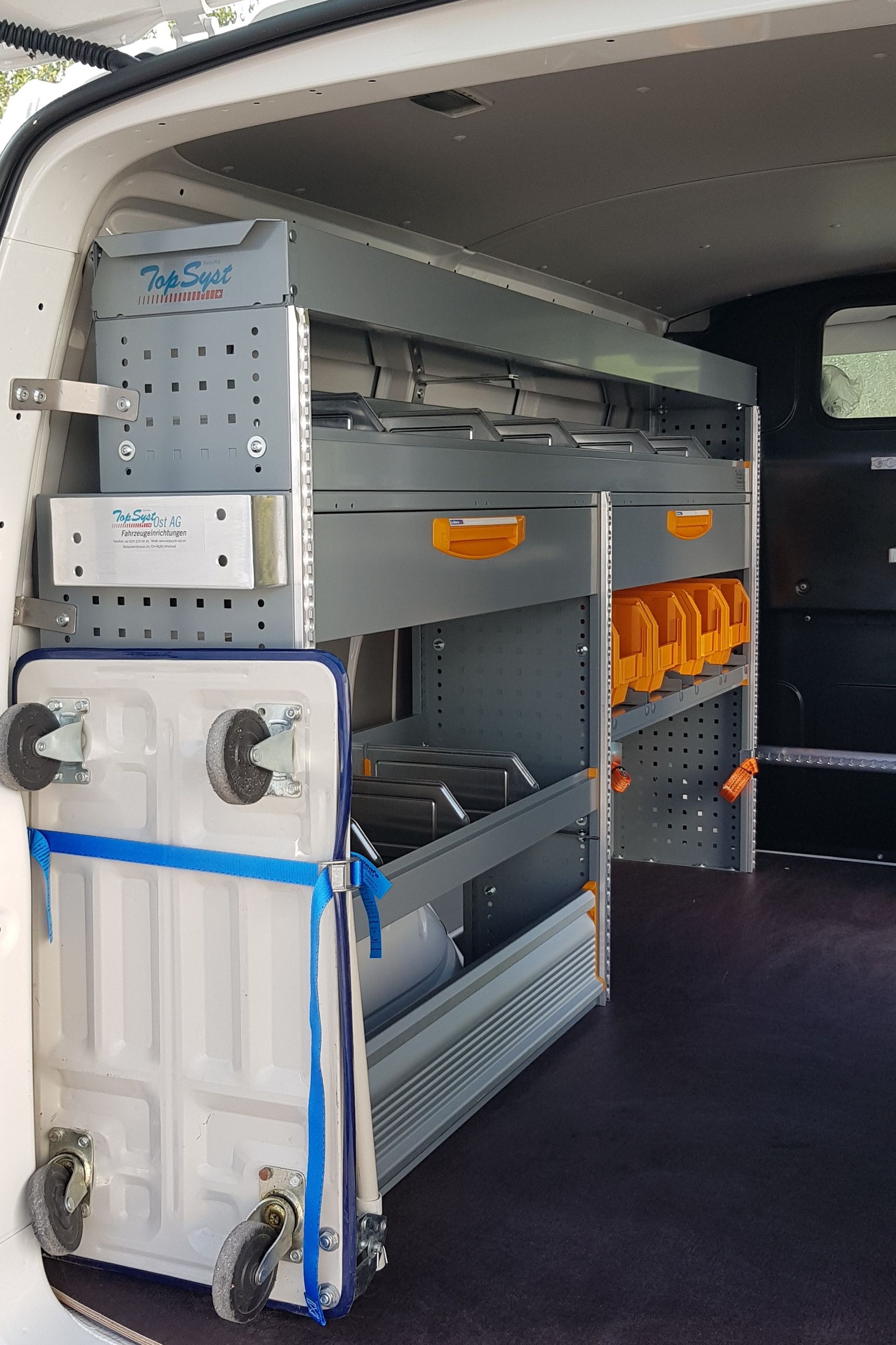 Das Innere eines Lieferwagens mit Regalen und Schubladen.