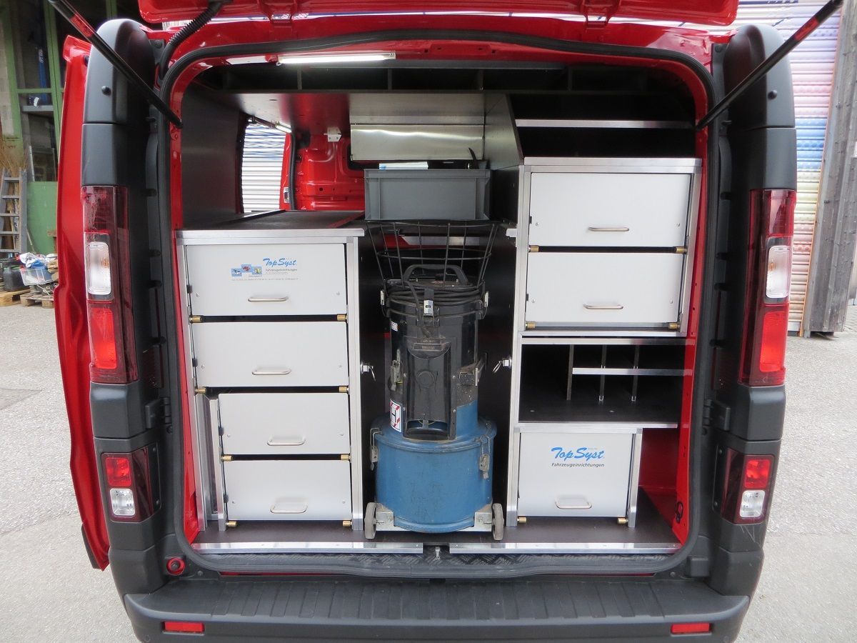 Die Rückseite eines roten Lieferwagens mit Schubladen und einem Staubsauger