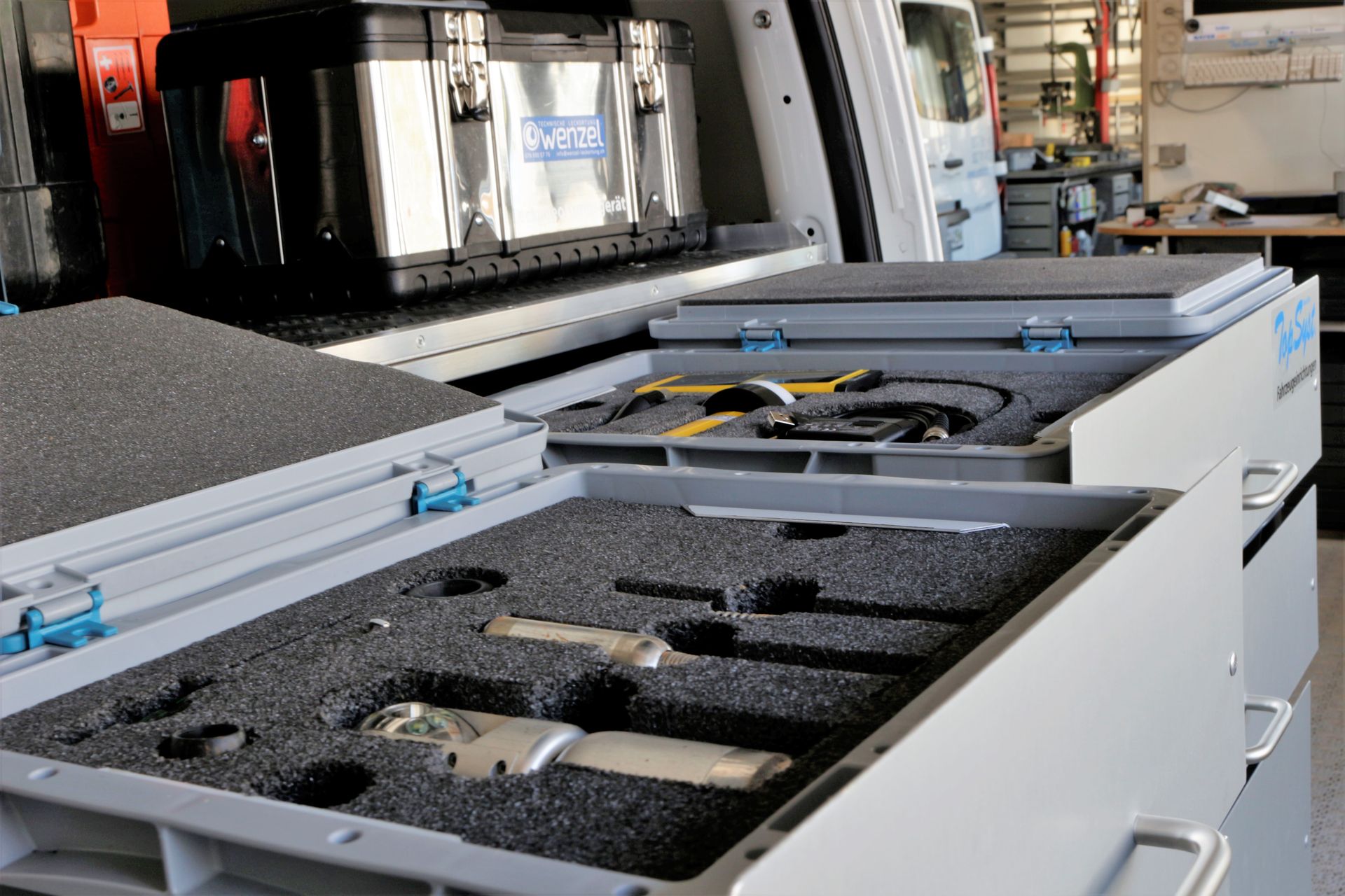 In einem Lieferwagen steht ein Werkzeugkasten auf einer Schublade.