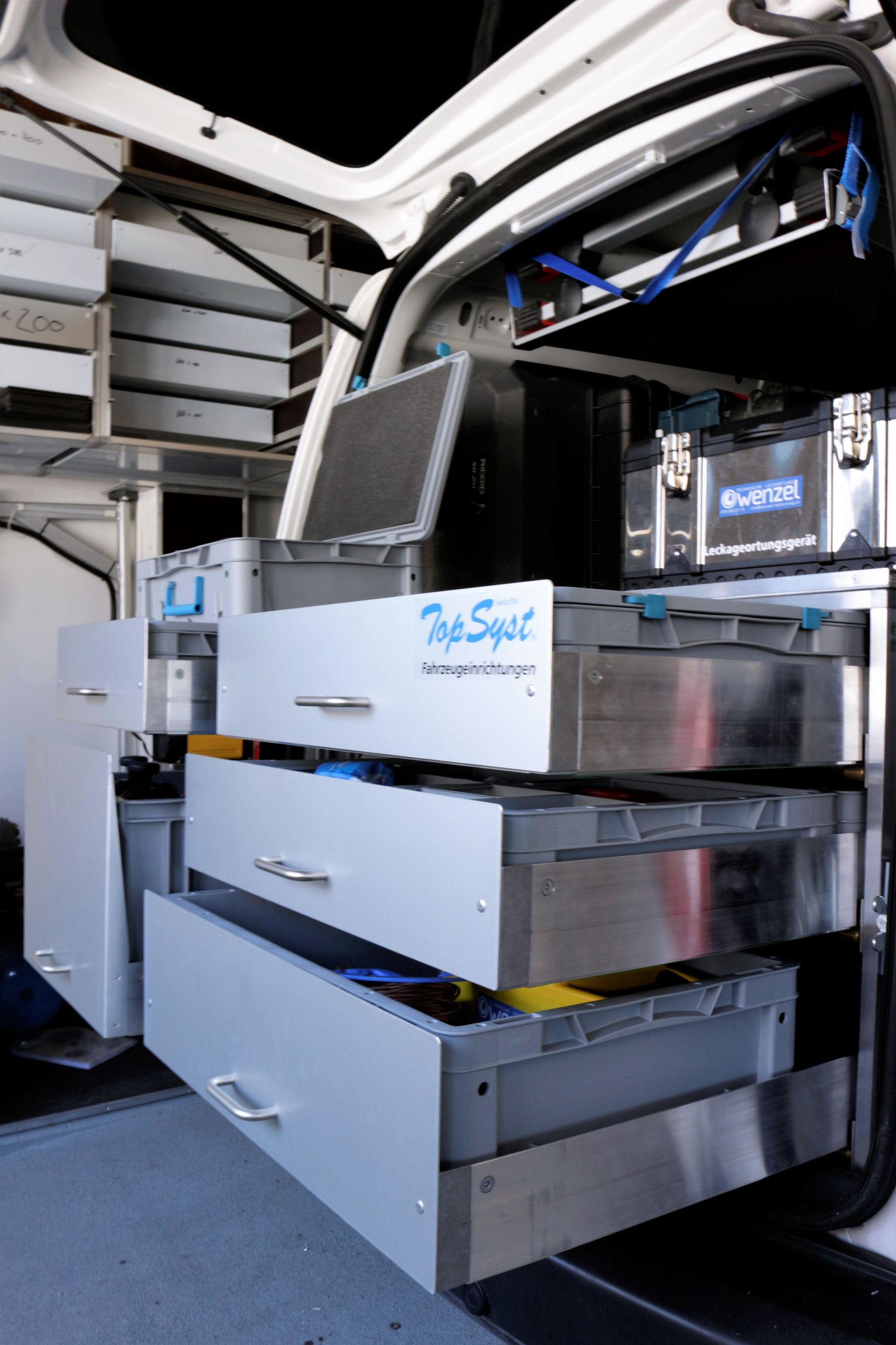 Ein weißer Van mit Edelstahlschubladen und einem Monitor.