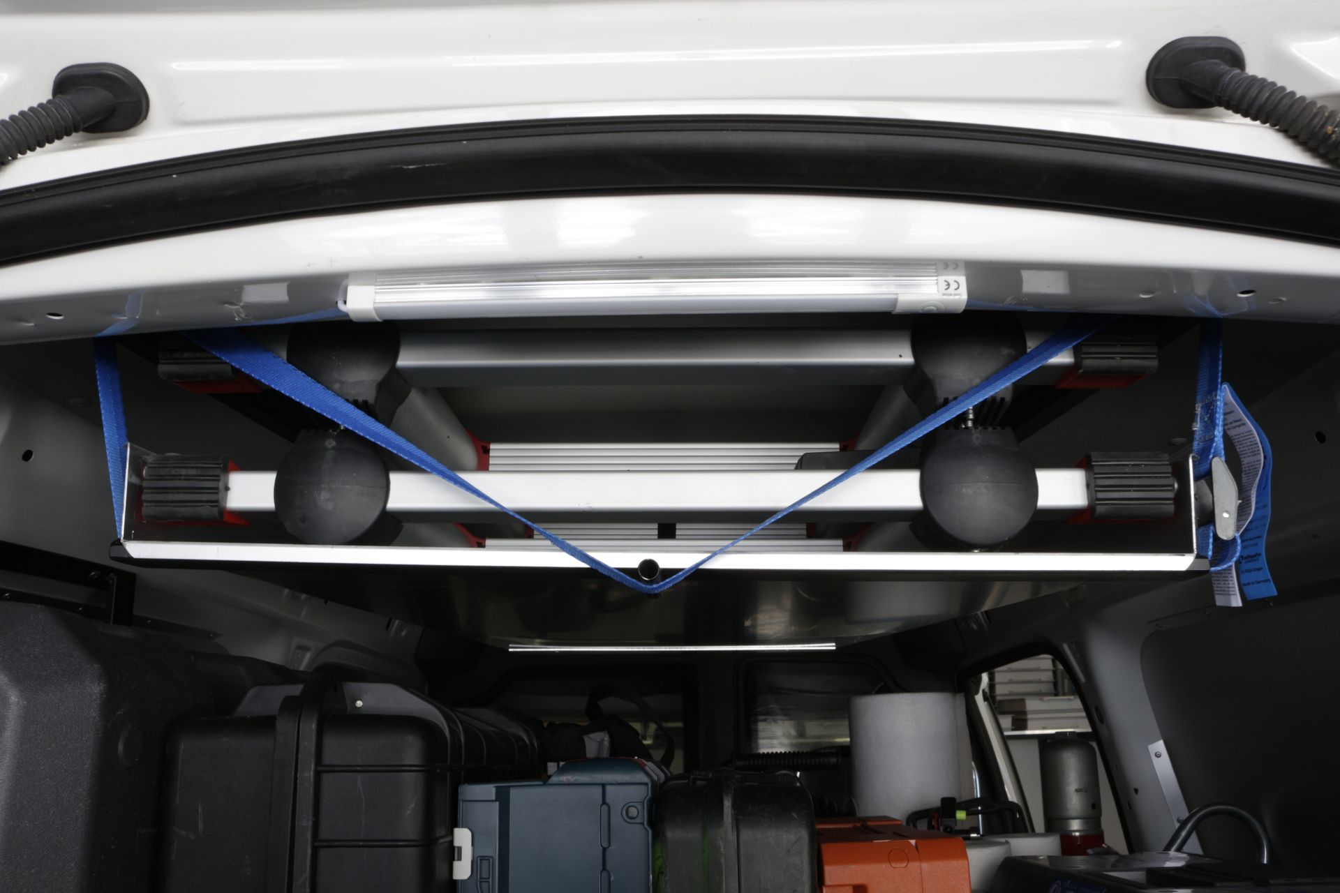 Ein weißer Lieferwagen mit einer an der Rückseite befestigten Leiter.