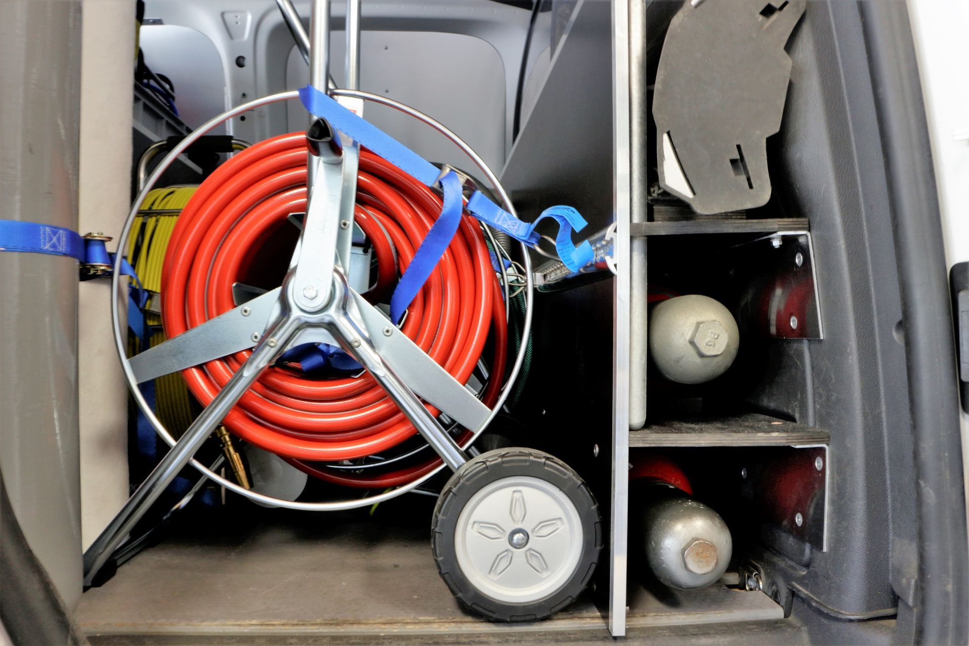 Auf einem Wagen im hinteren Teil eines Lieferwagens liegt ein Schlauch.