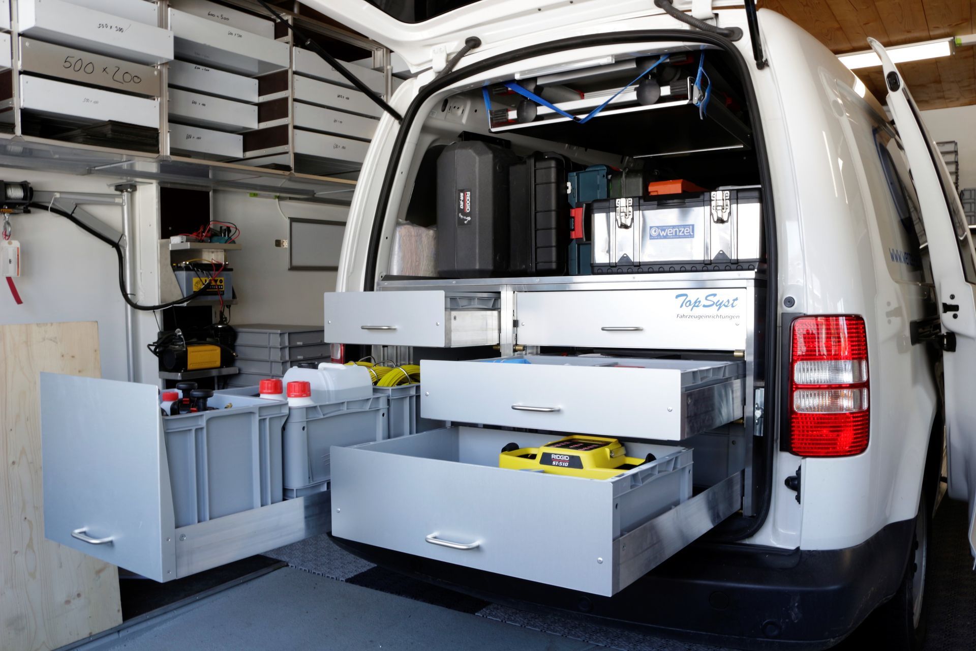 Ein weißer Lieferwagen mit vielen Schubladen im hinteren Bereich