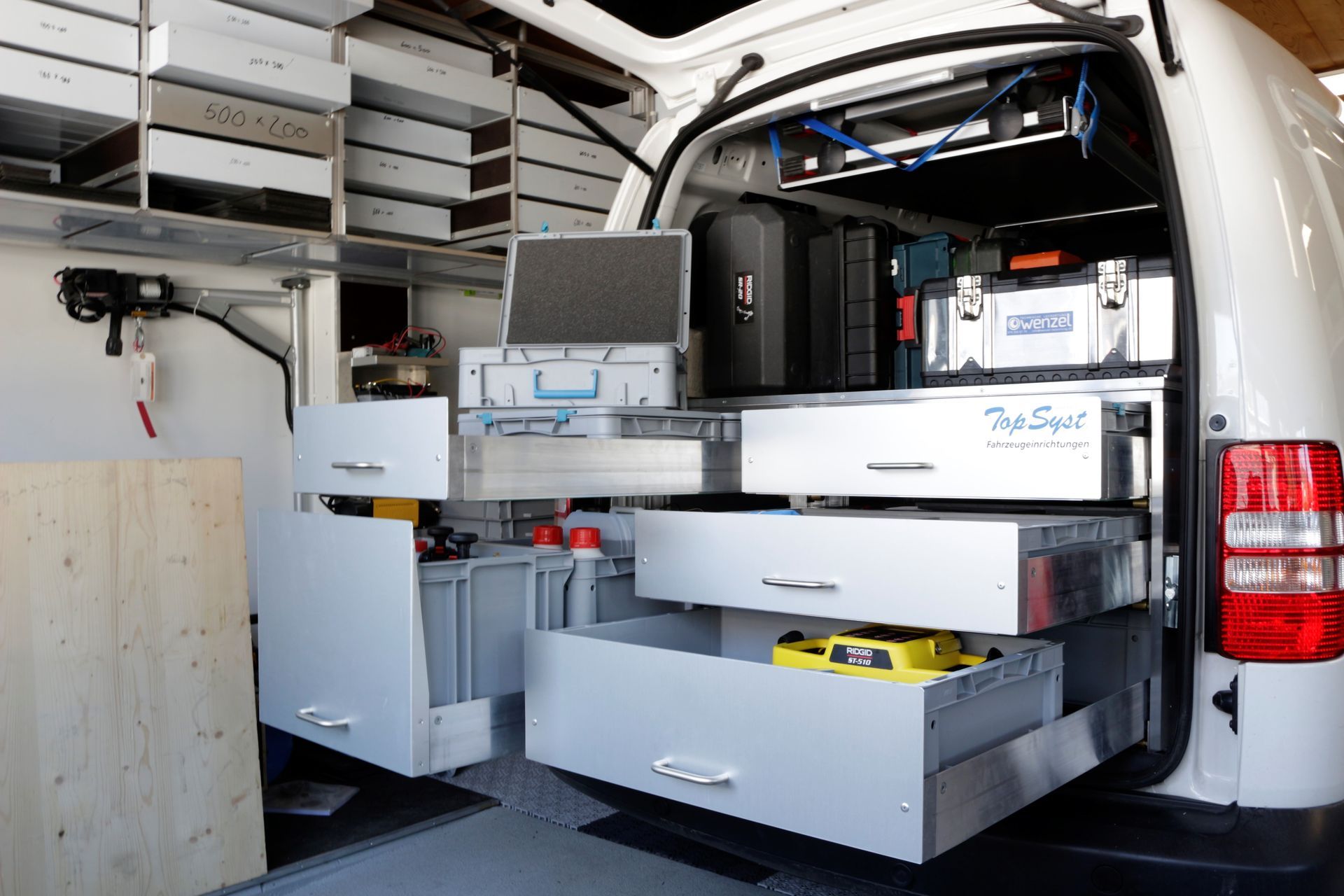 Ein weißer Lieferwagen mit vielen Schubladen und Werkzeugen darin