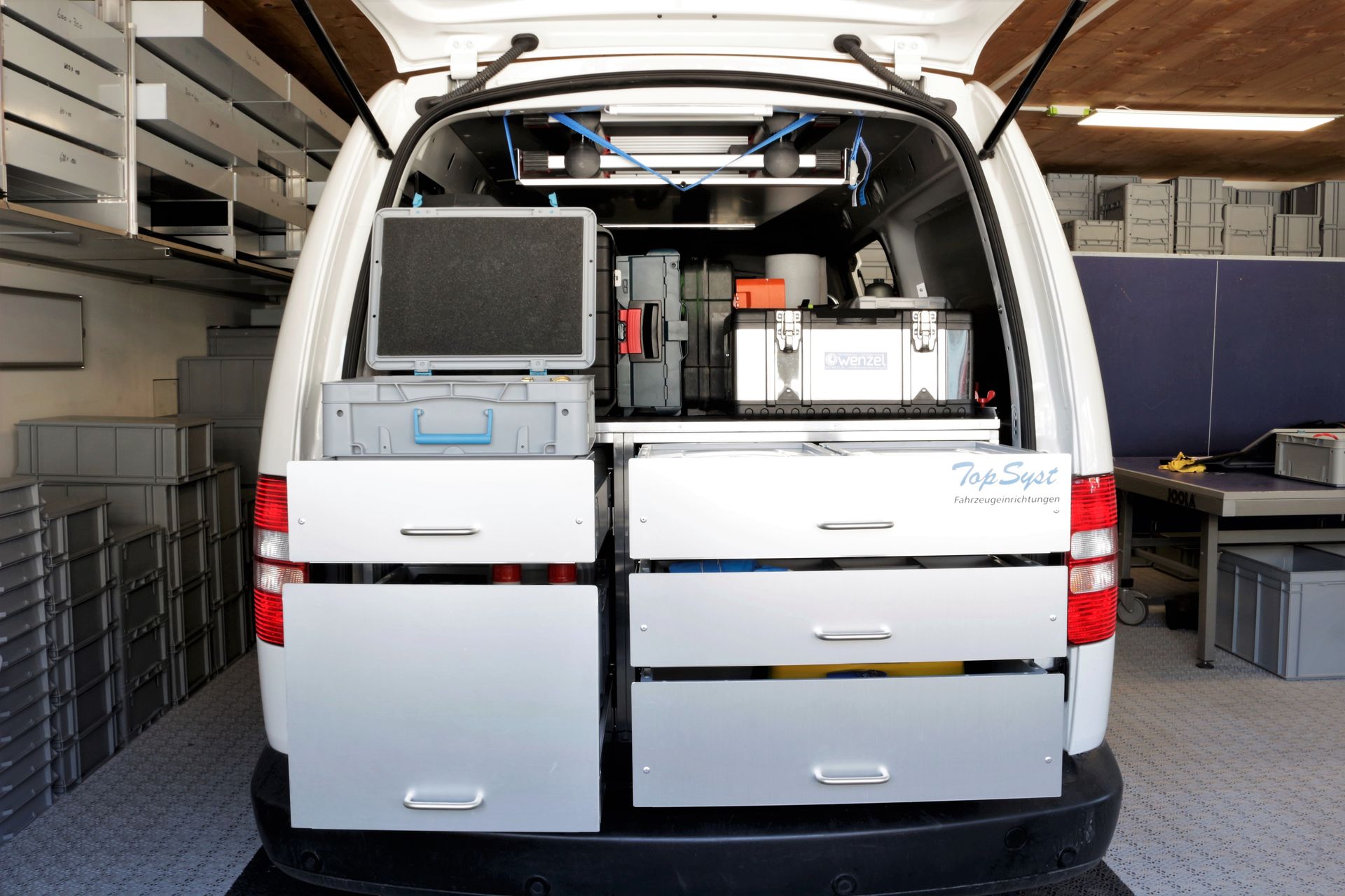 Die Rückseite eines weißen Lieferwagens mit Schubladen und einem Monitor