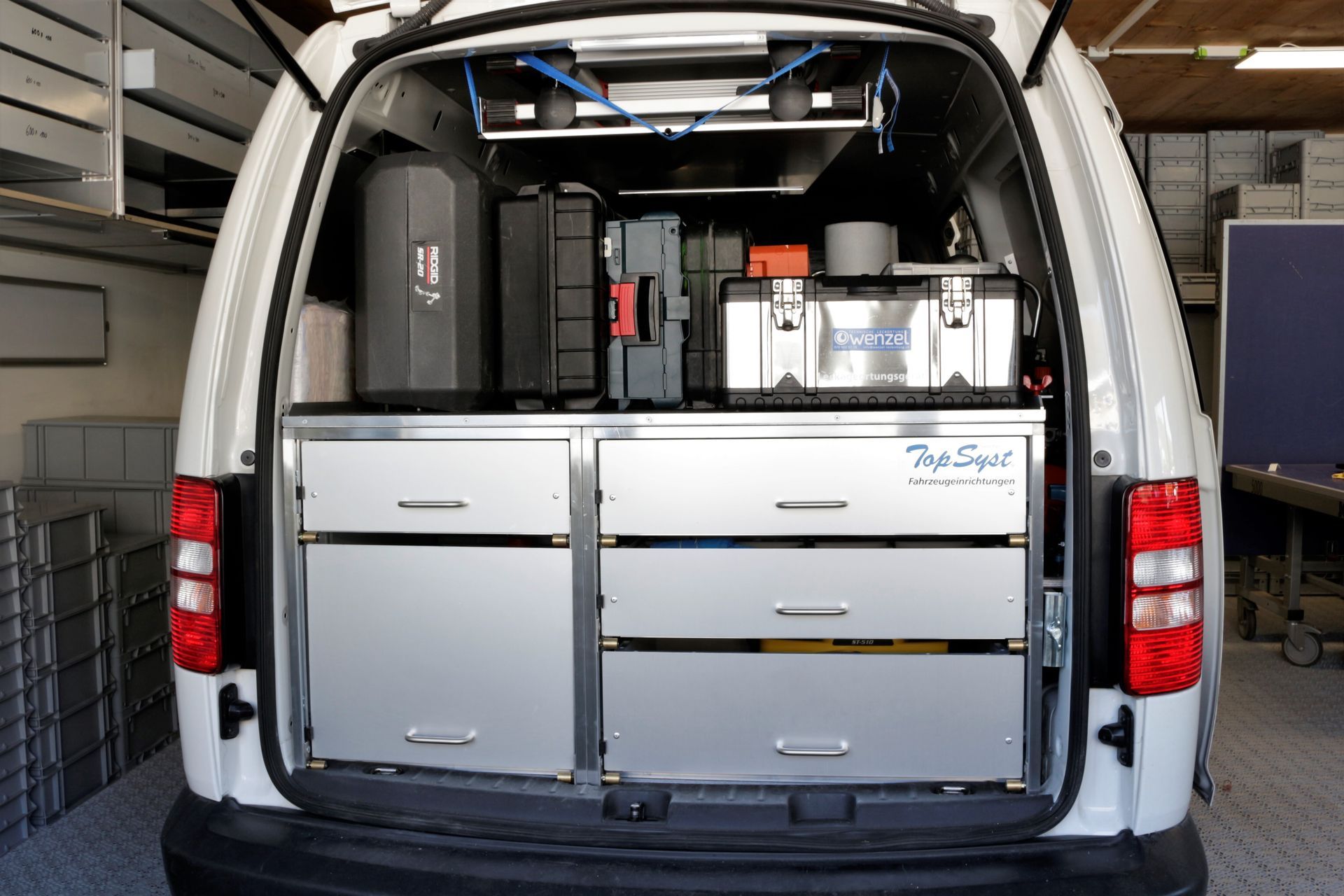 Die Rückseite eines weißen Lieferwagens mit Schubladen und einem Werkzeugkasten