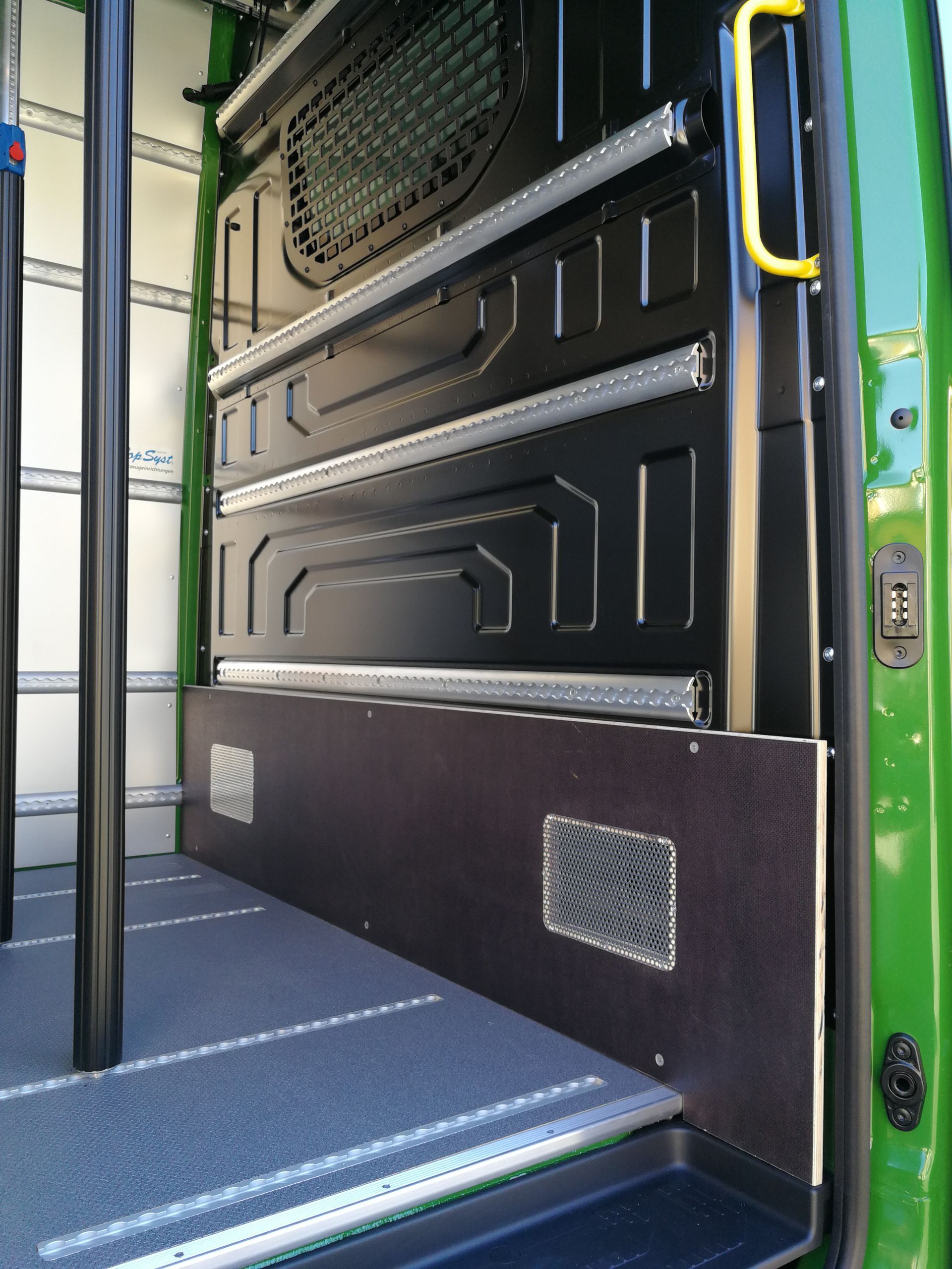 Ein grüner Van hat einen gelben Griff an der Tür