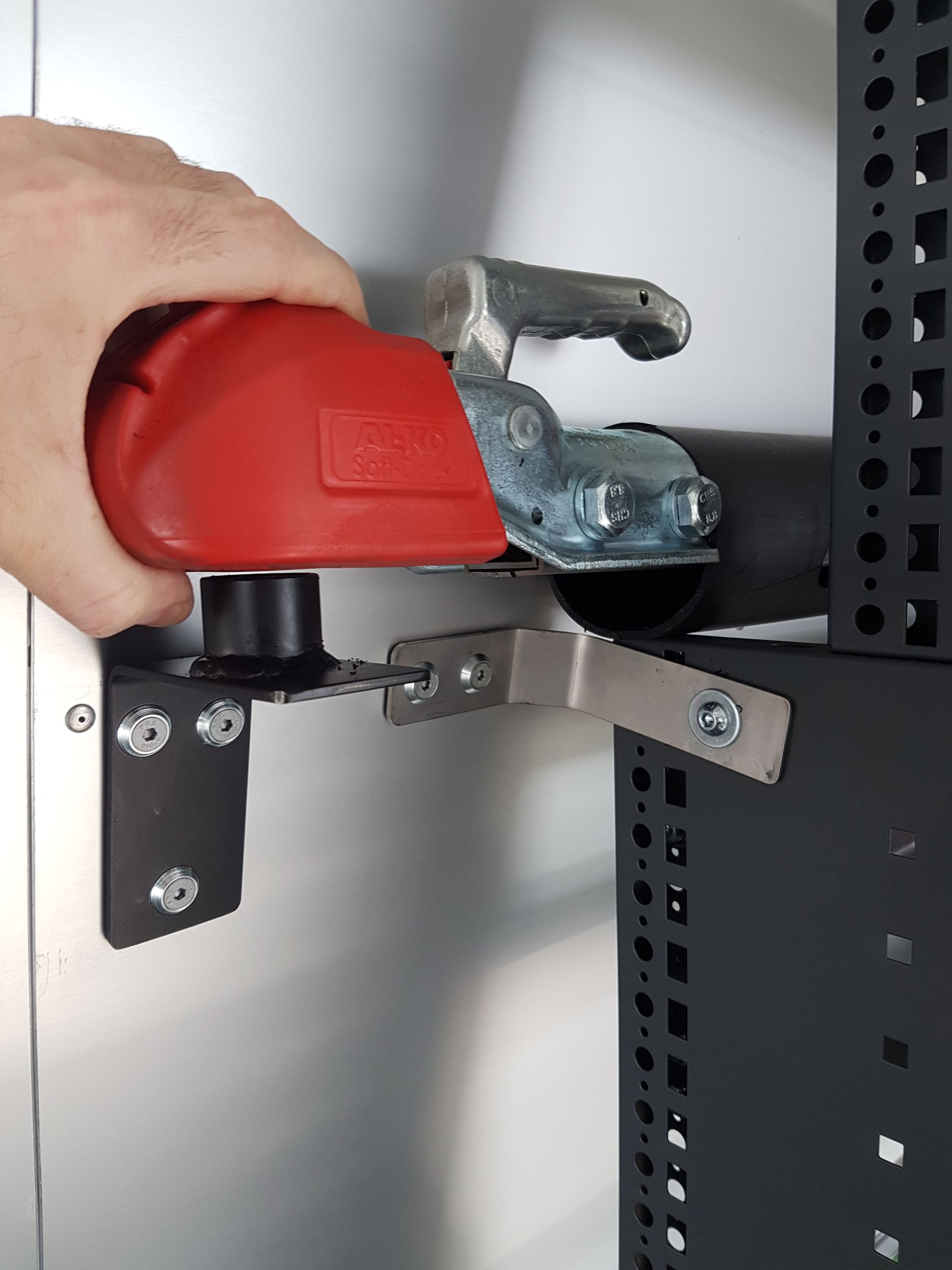 Eine Person hält einen roten Gegenstand in der Hand.