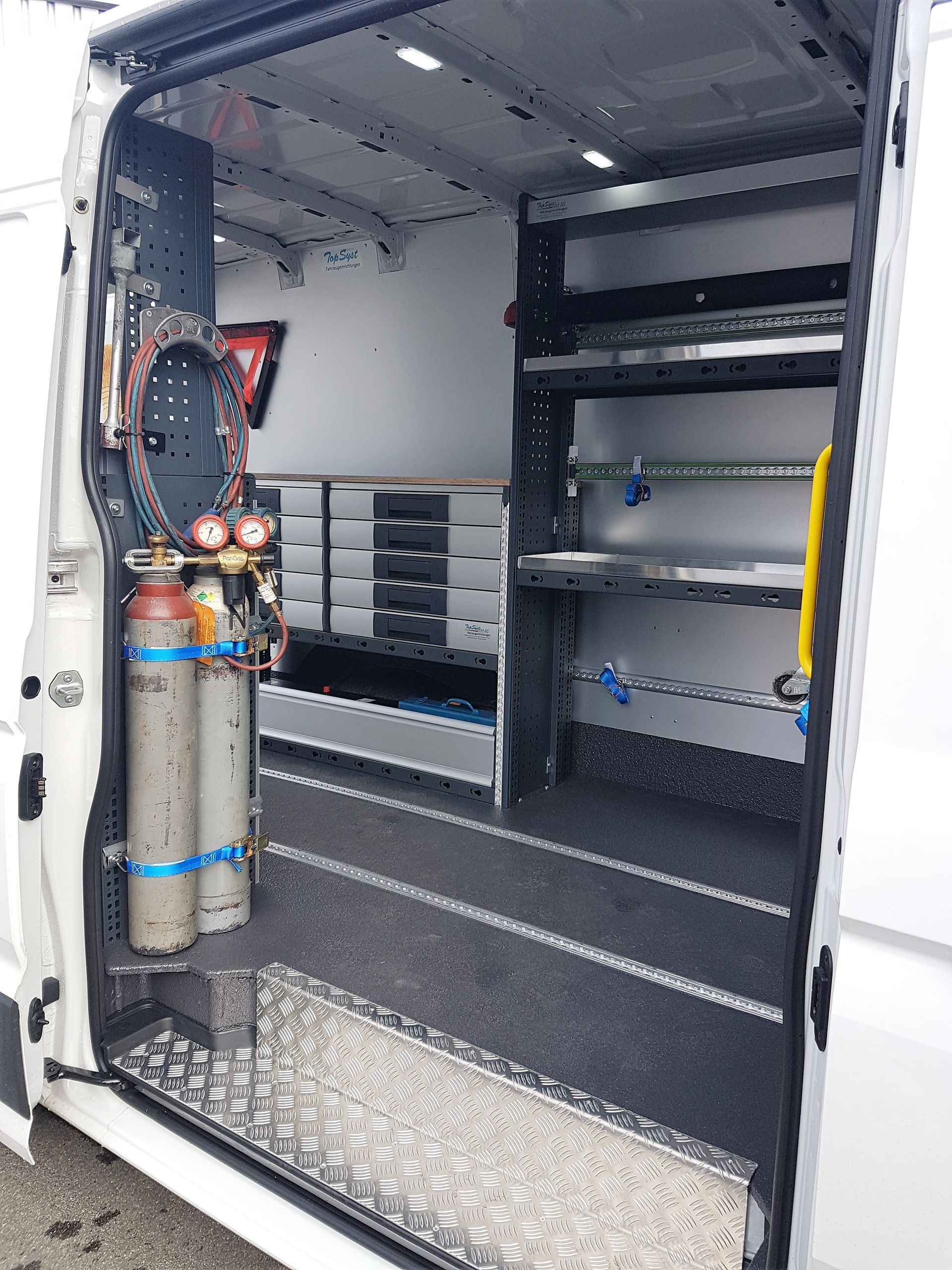 Das Innere eines weißen Lieferwagens mit offener Tür.