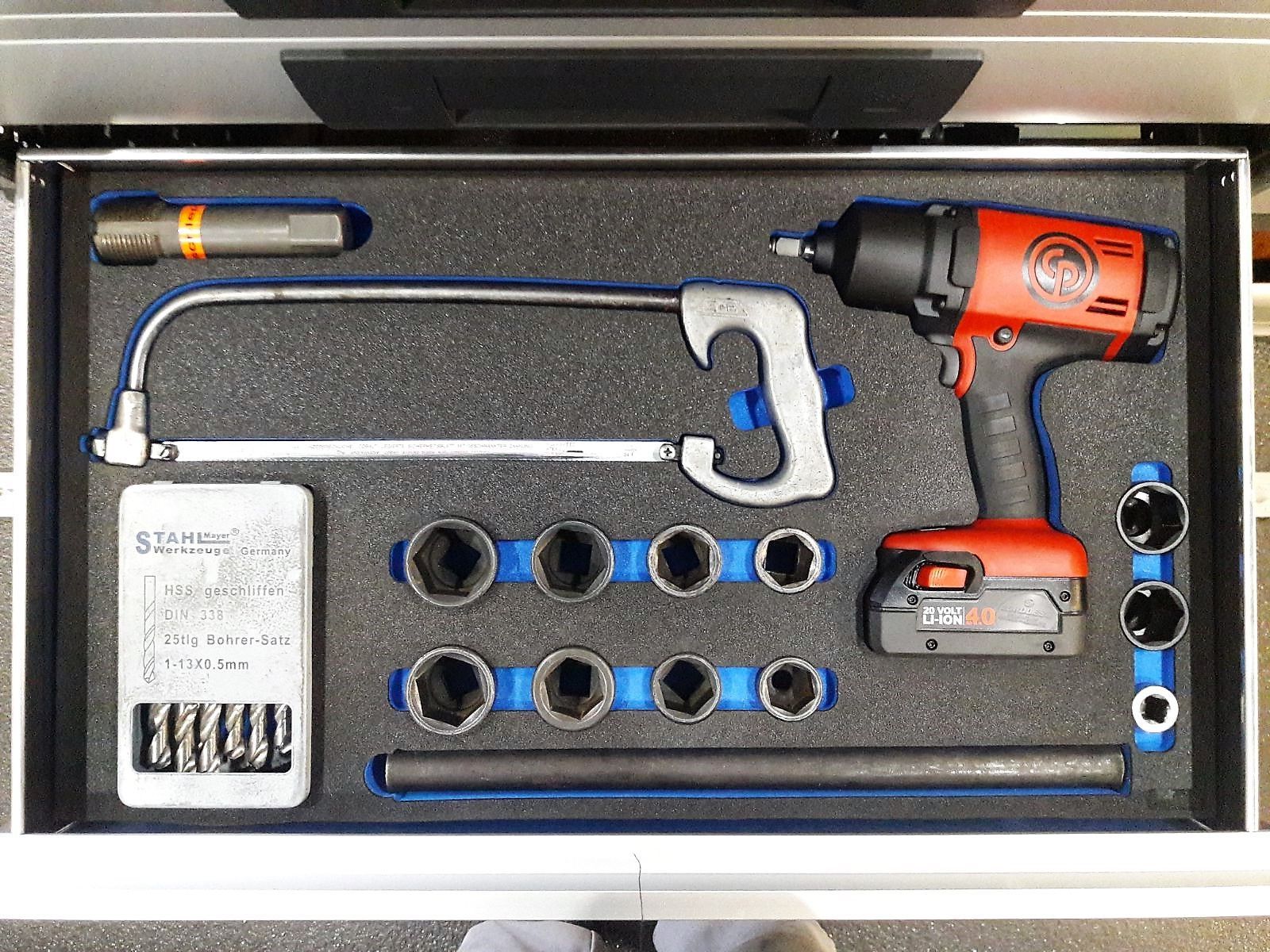 Eine Schublade voller Werkzeuge, darunter eine Bohrmaschine und eine Säge