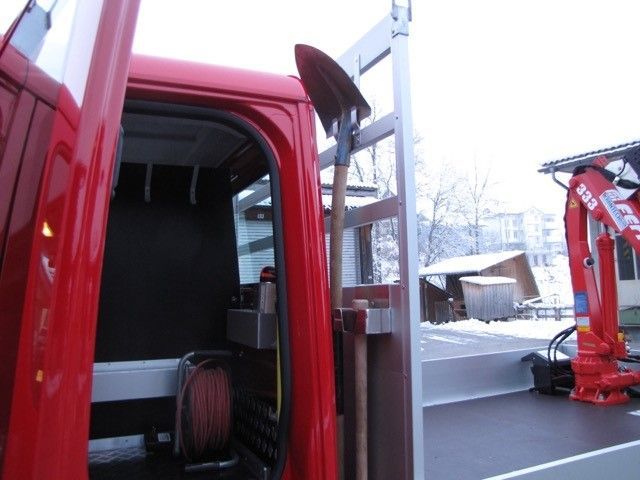 Ein roter LKW mit einem Kran auf der Rückseite