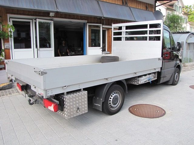 Ein Pritschenwagen steht vor einem Gebäude