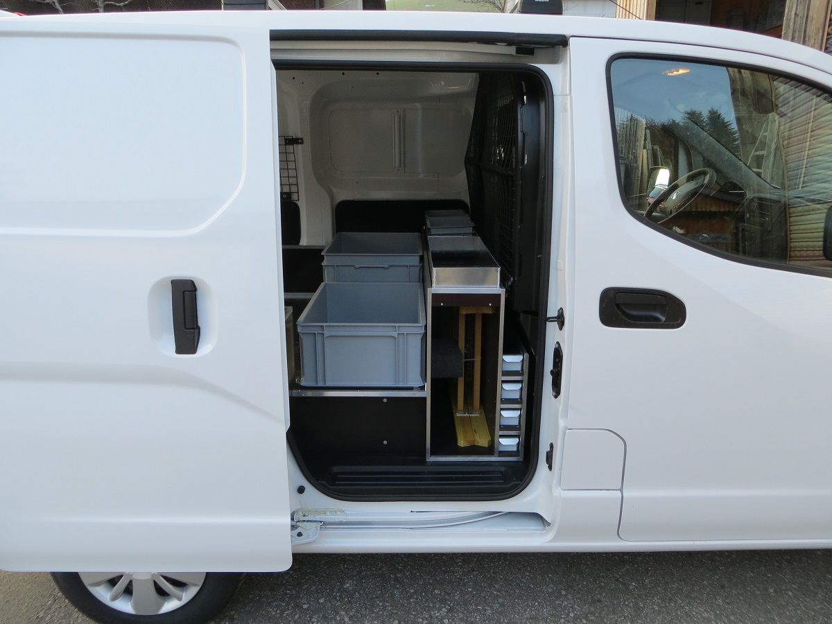 Ein weißer Lieferwagen mit offener Tür und Kisten auf der Ladefläche